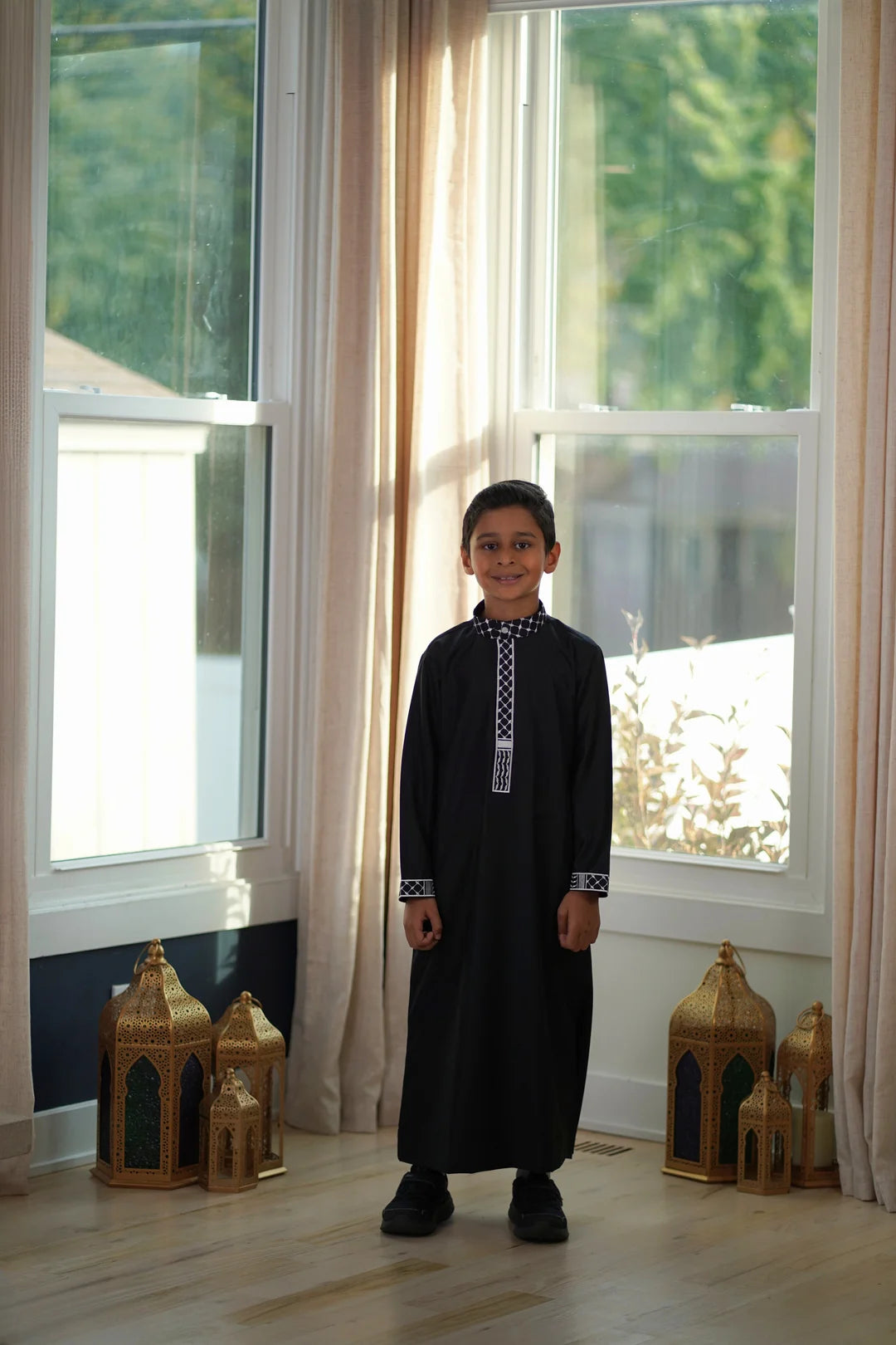 Detail view of the matching white embroidery on the sleeve cuffs of the boys black jubba