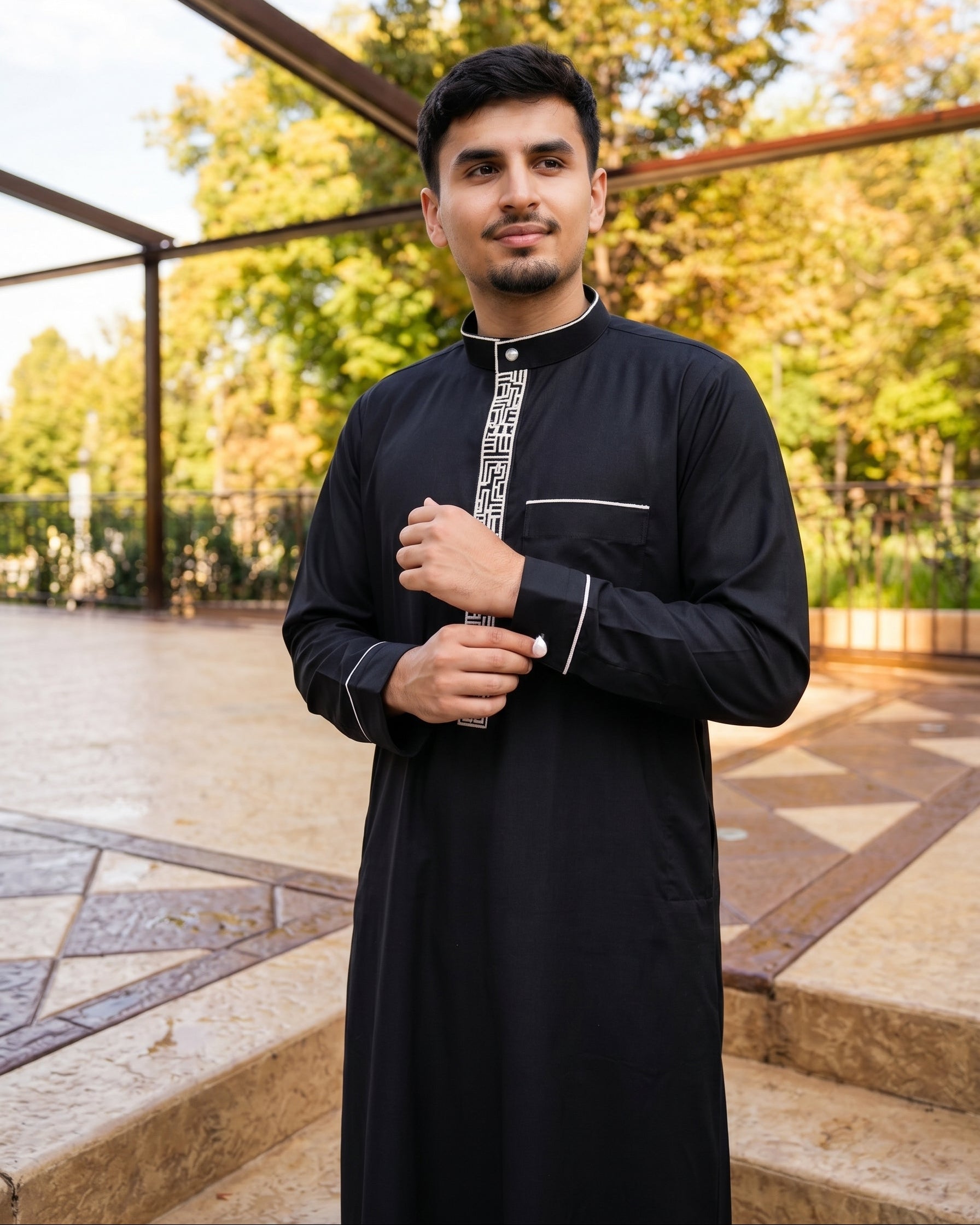 Close-up detail of black thobe with white embroidery, premium fabric and stitching quality comparable to Burda style and Shukr clothing, The Topiwala Chicago online luxury menswear.