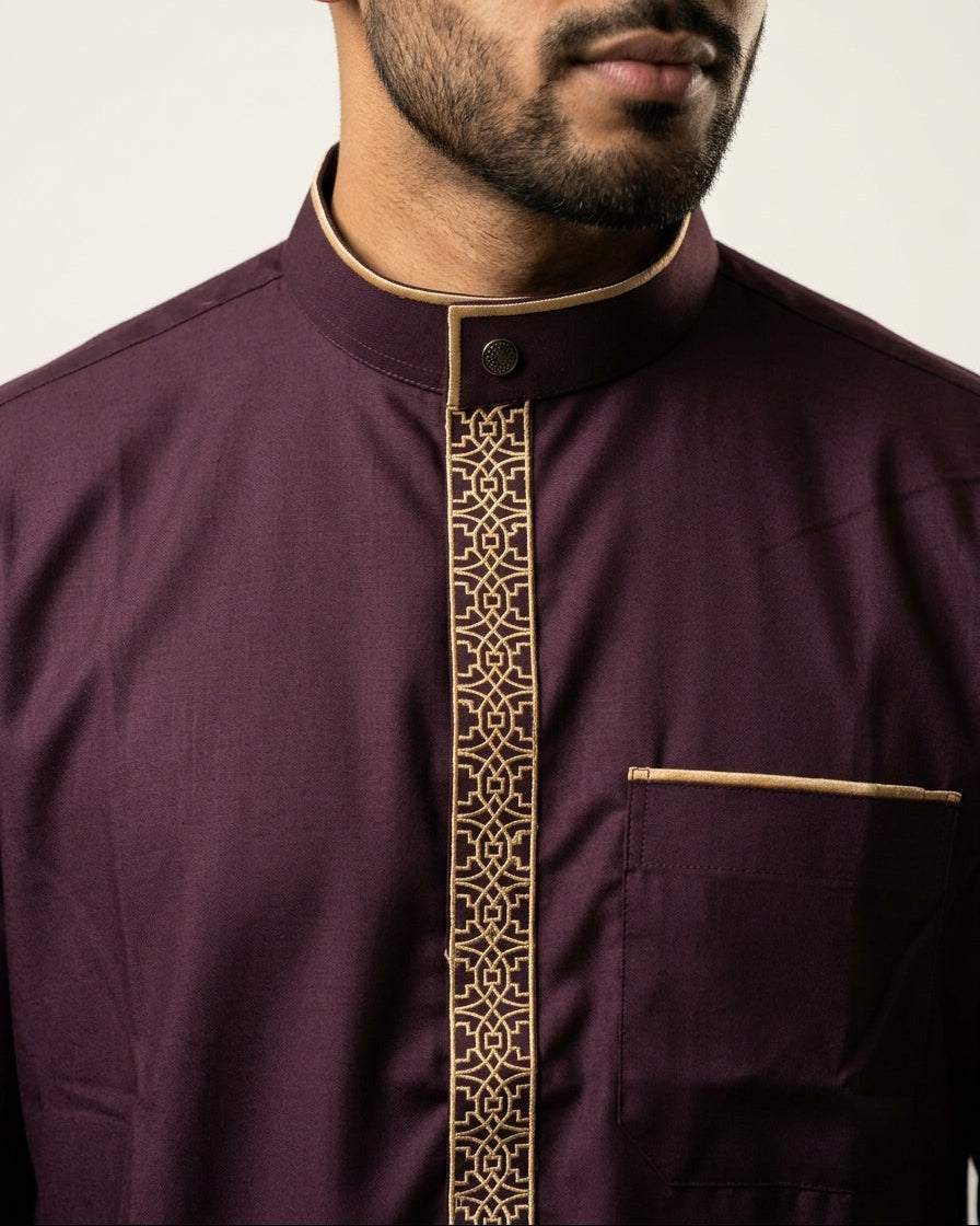 Close up of premium maroon men's thobe showing bronze piping and geometric placket embroidery, mandarin collar jubbah, formal Islamic menswear, designer Sunnah wear.