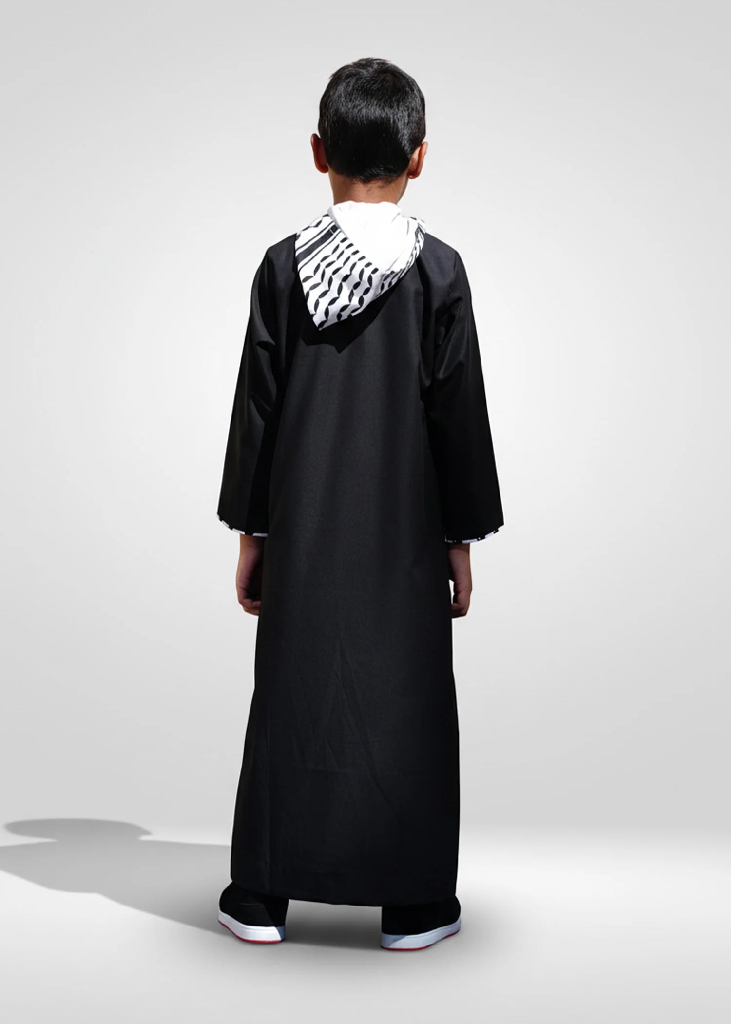 Flat lay image of the folded Black Palestine Hoodie Kids Thobe showing the premium design elements