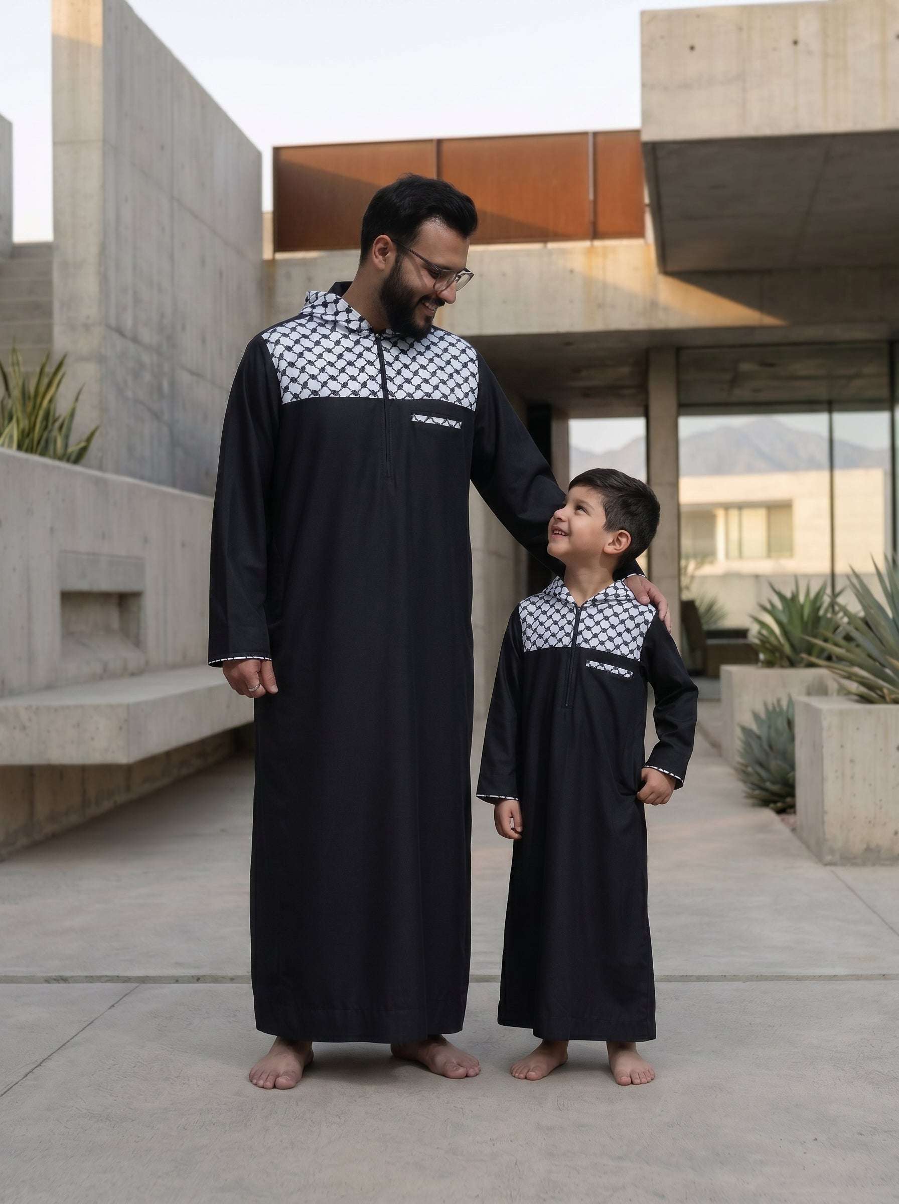 Black Palestine hoodie thobe for men and boys, worn by a model outdoors