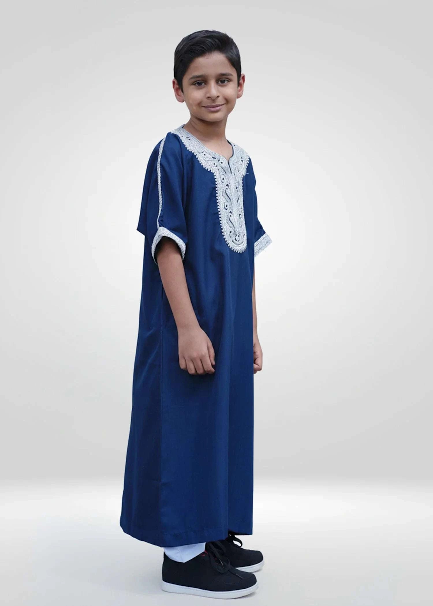 Blue Moroccan gandora with silver embroidery for boys, worn by a model outdoors