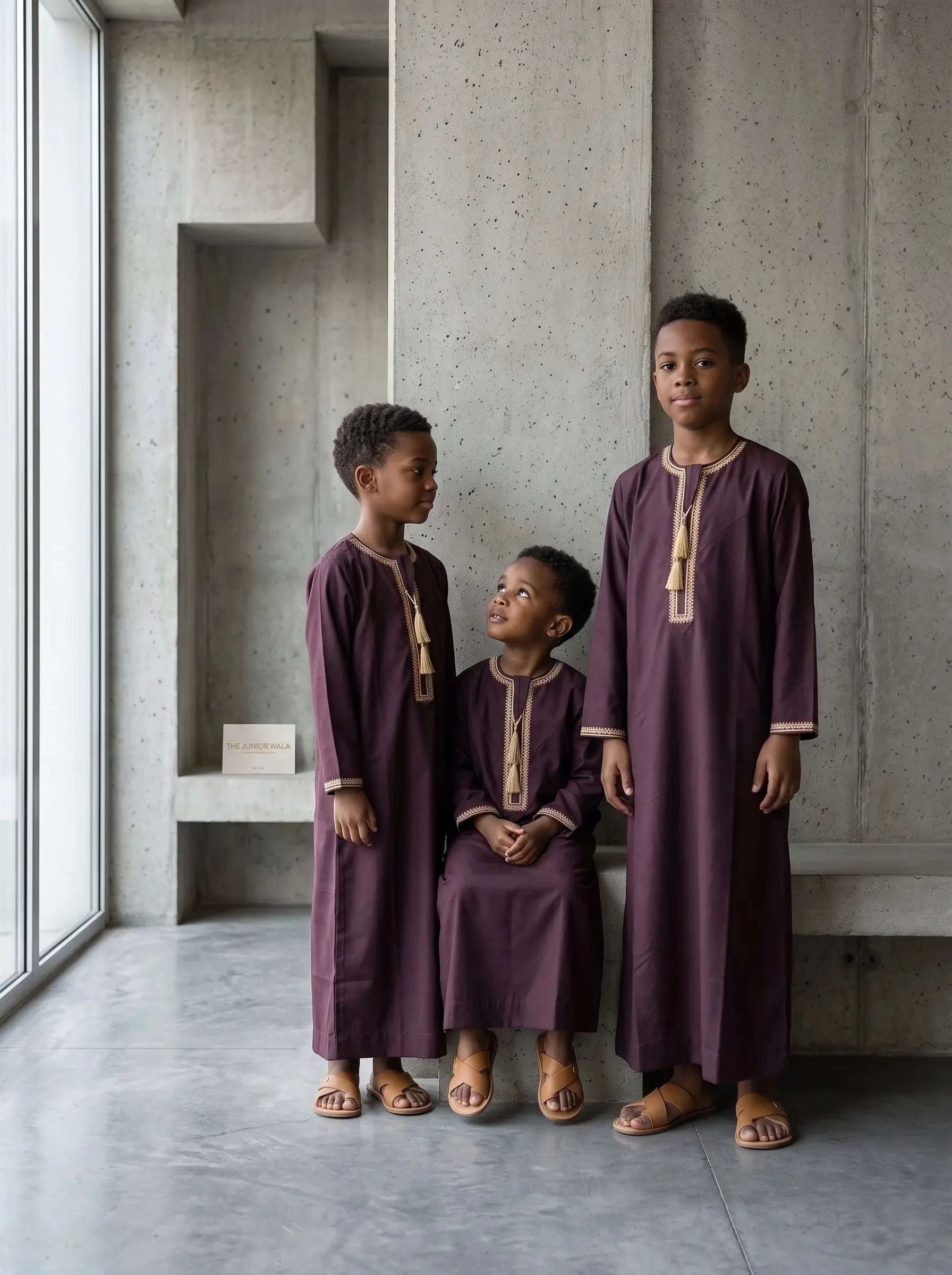 Boys burgundy Emirati V-neck thobe with braided tarboush – kids maroon Dubai style jubba showing premium embroidery and tassel detail. Top rated Eid thobe for boys in the USA, Muslim kids formal wear for weddings, Nikkah, Jumu'ah and Ramadan. Luxury quality kids Islamic clothing at affordable prices with better value than designer modest wear brands. The Topiwala kids Emirati thobes collection – breathable full-length modest fit, sizes 18–50, ships across the United States.