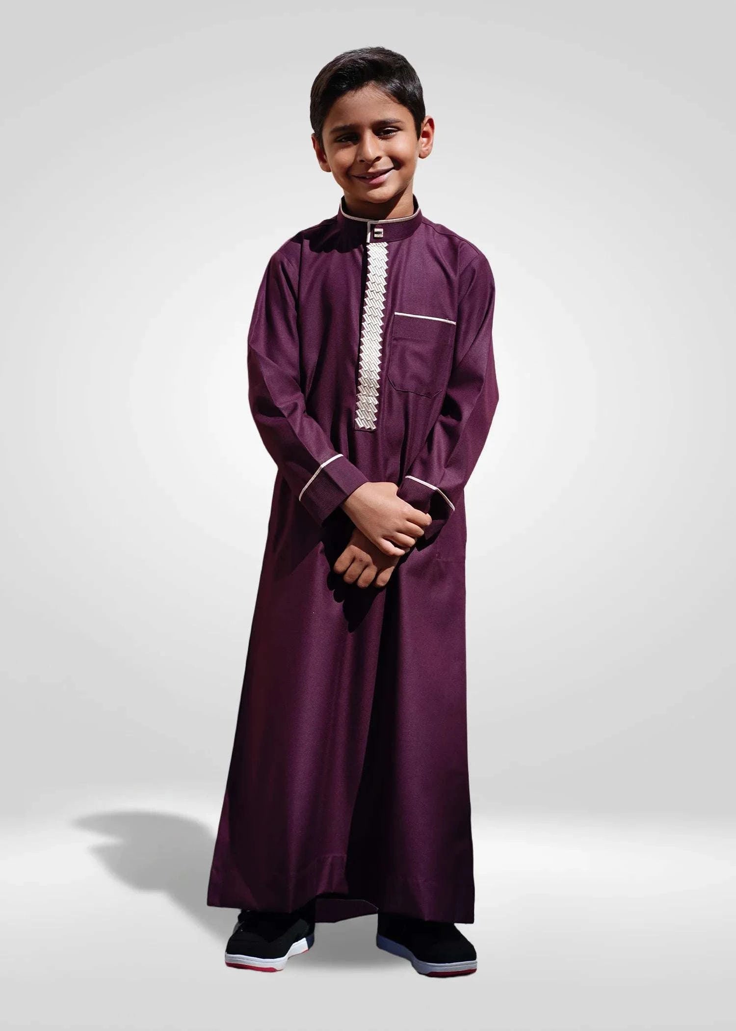 Front view of smiling boy wearing Royal Maroon and Gold Embroidered Thobe for Eid 2025