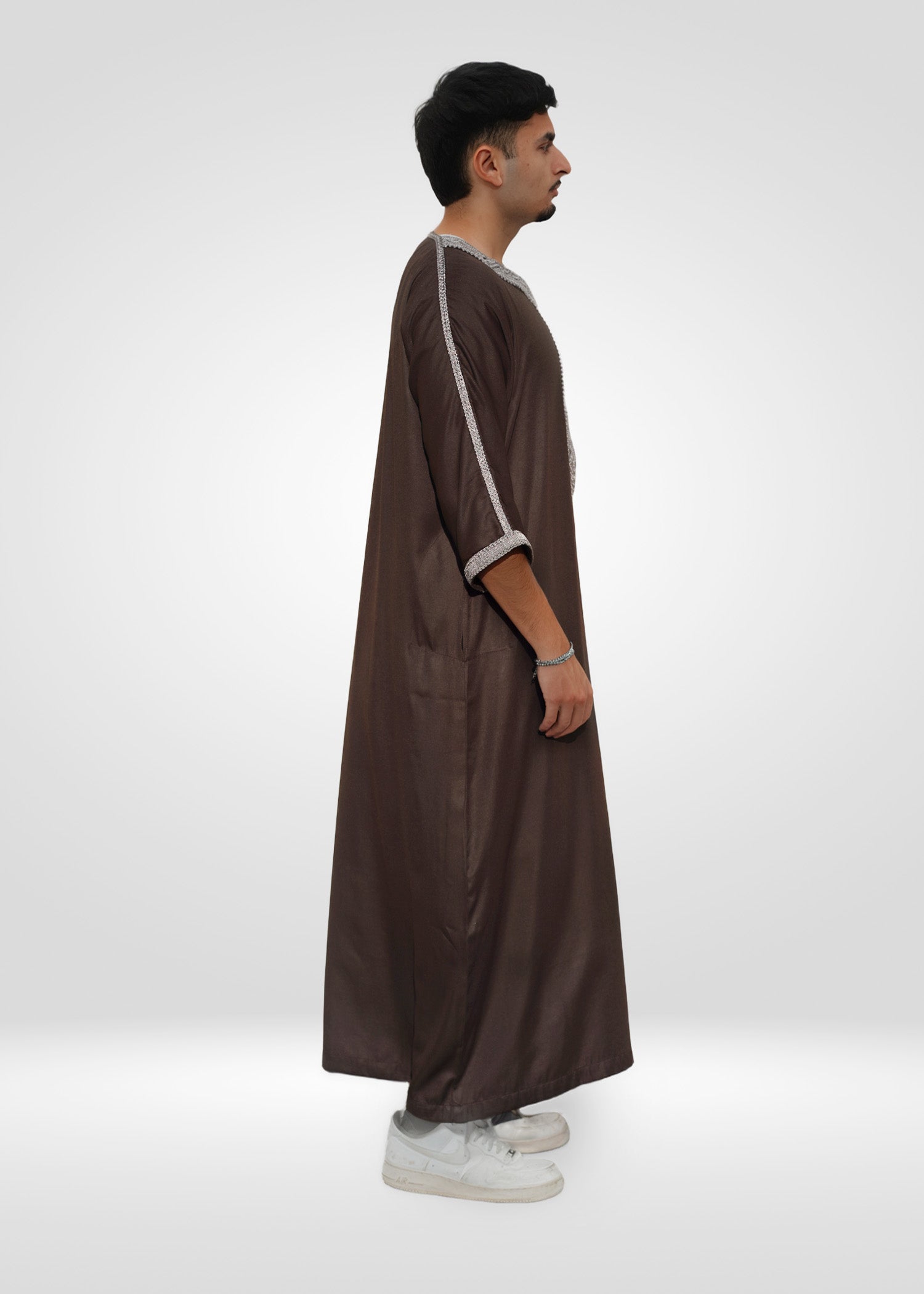 Macro shot of the premium fabric texture and embroidery stitching on the men's thobe