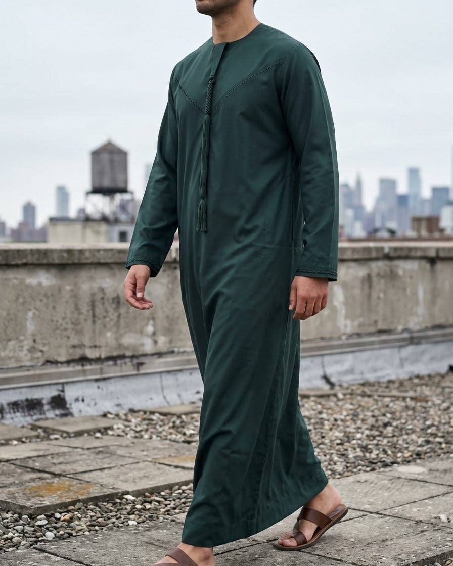 Men's Dark Green Emirati Thobe – Tailored Jubba, three-quarter stand, city edge · city rooftop, overcast – The Topi Wala