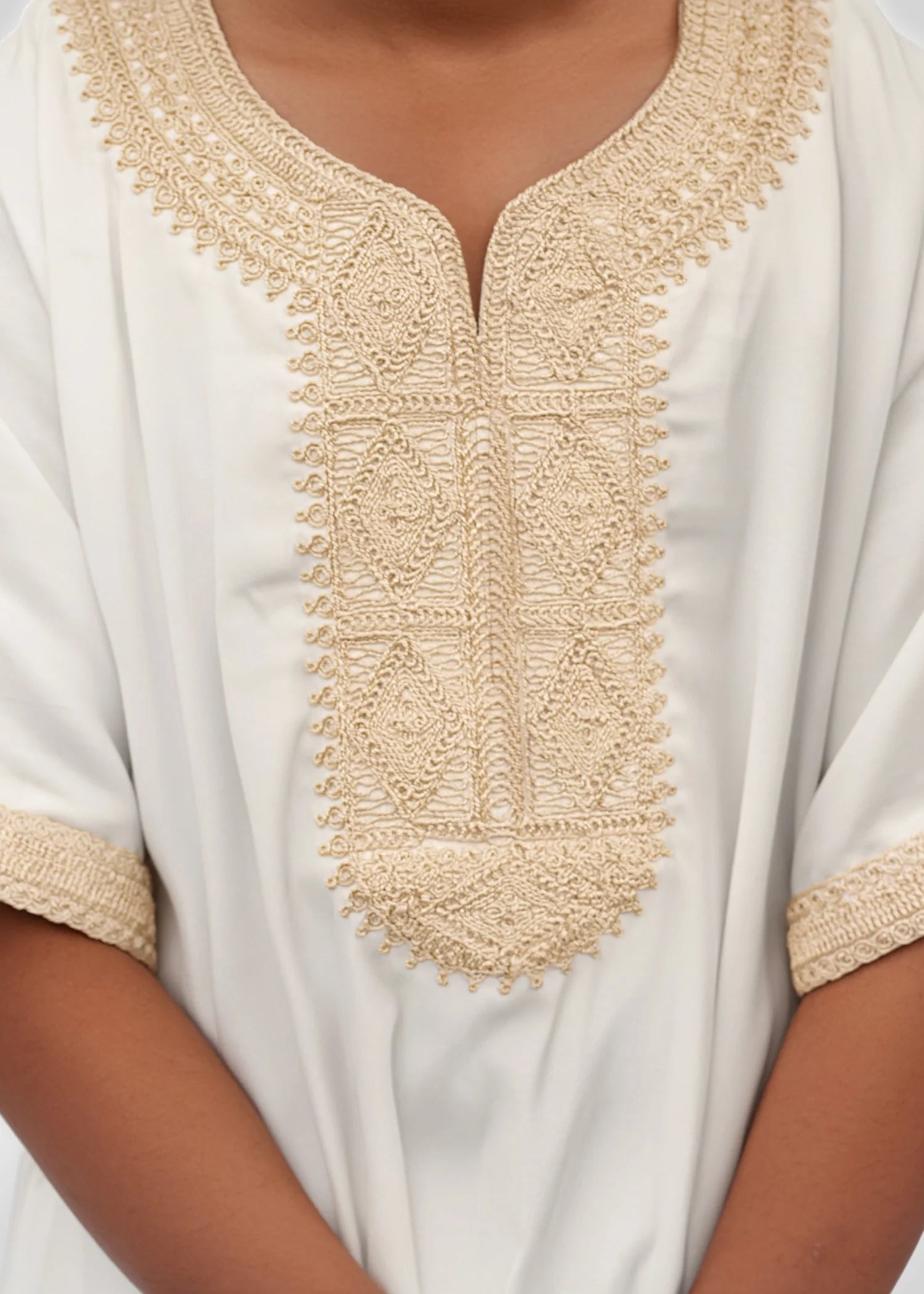 Close up of the luxurious gold stitching on the chest of the white boys thobe