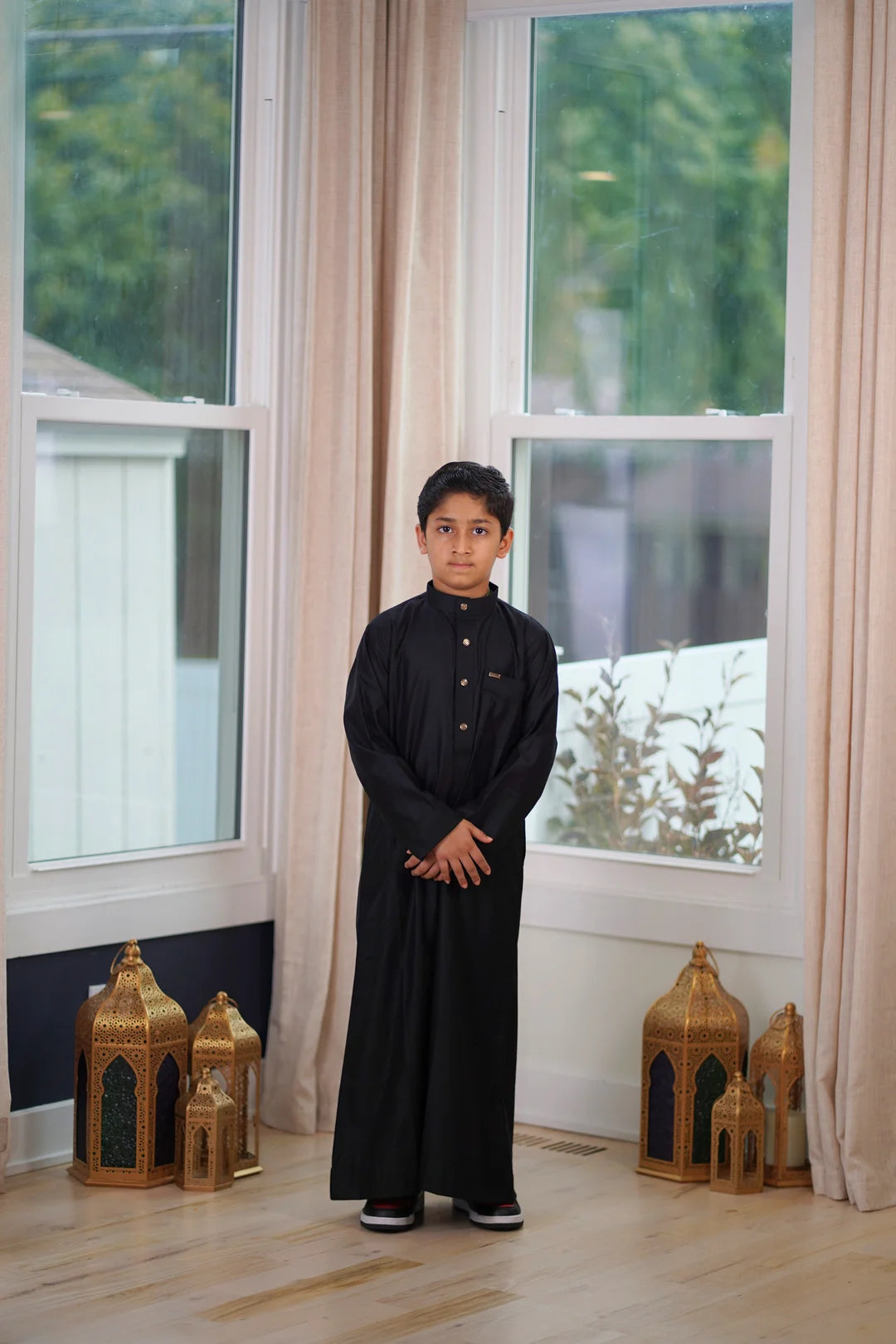 Detail view of the functional deep side pocket on the boys black jubba