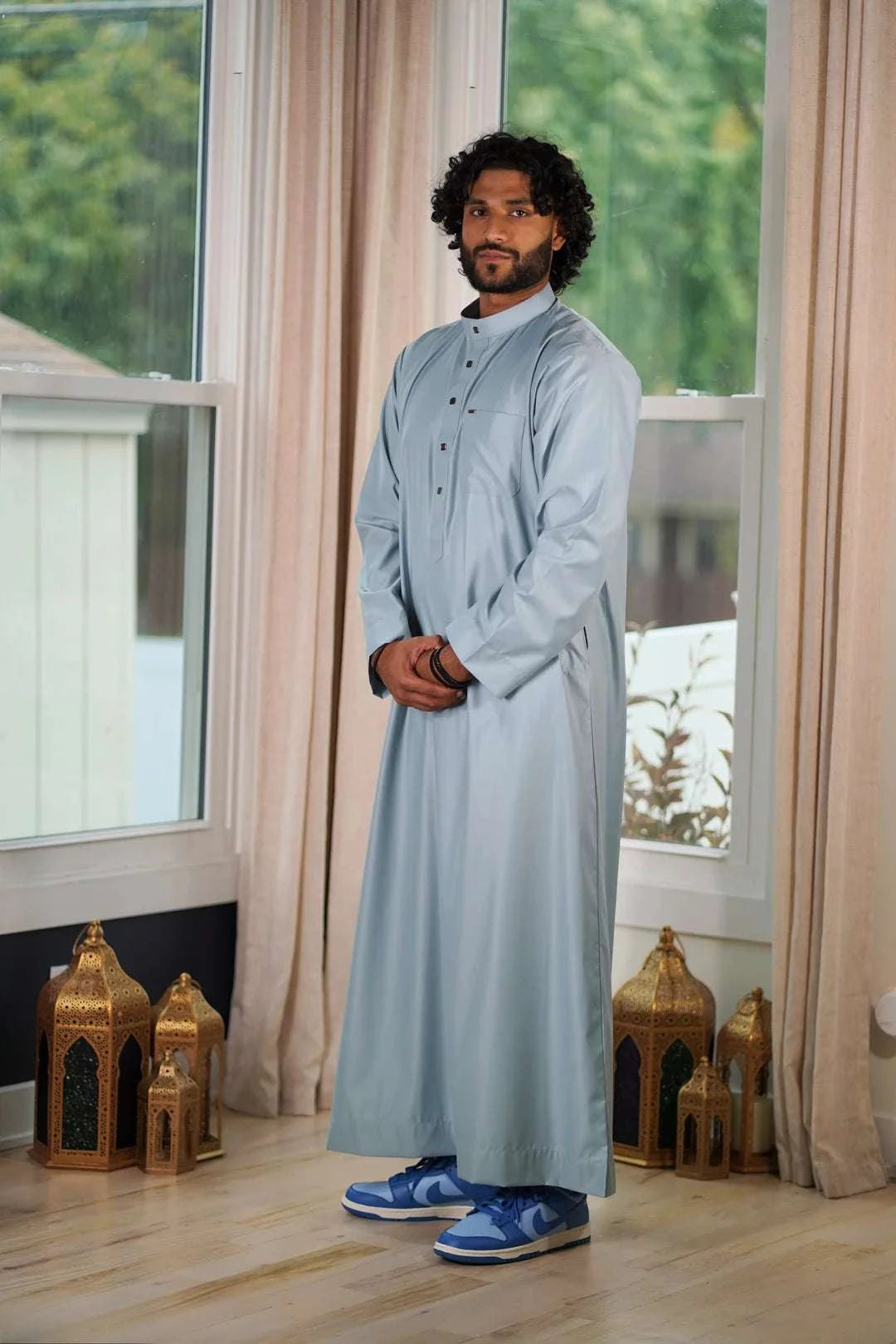 Light blue thobe with everyday mandarin collar for men, styled on a model outdoors
