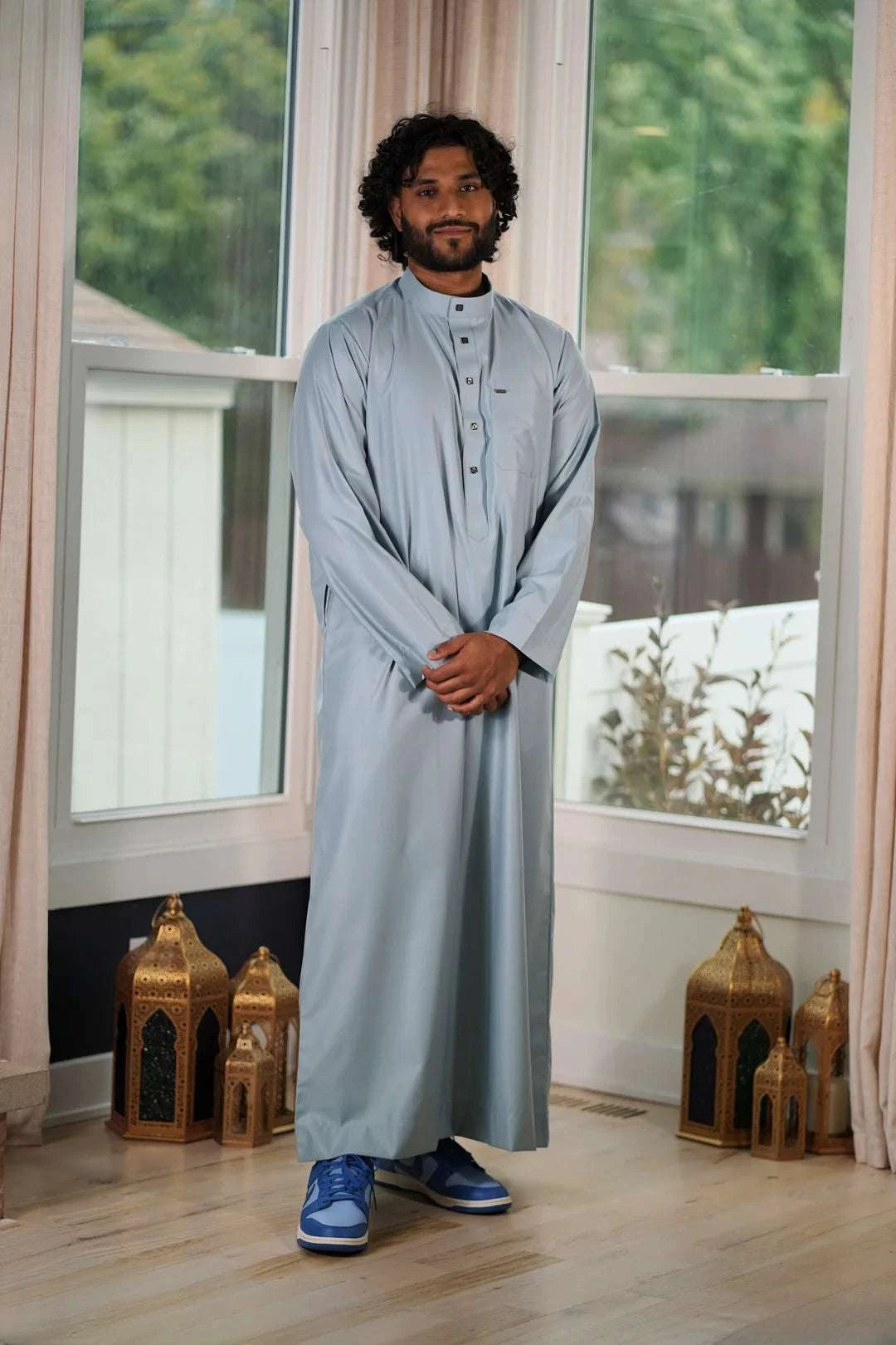 Light blue thobe with everyday mandarin collar for men, worn by a model outdoors