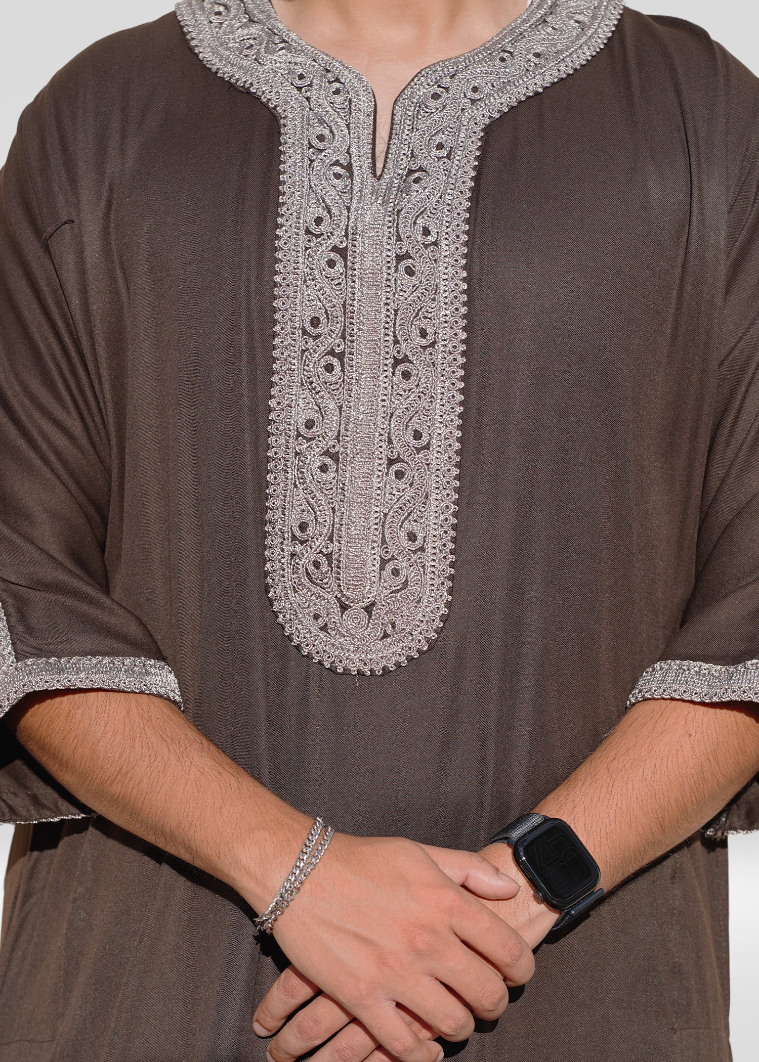 Model lifestyle shot emphasizing premium men's brown Thobe, suitable for Eid and special occasions.