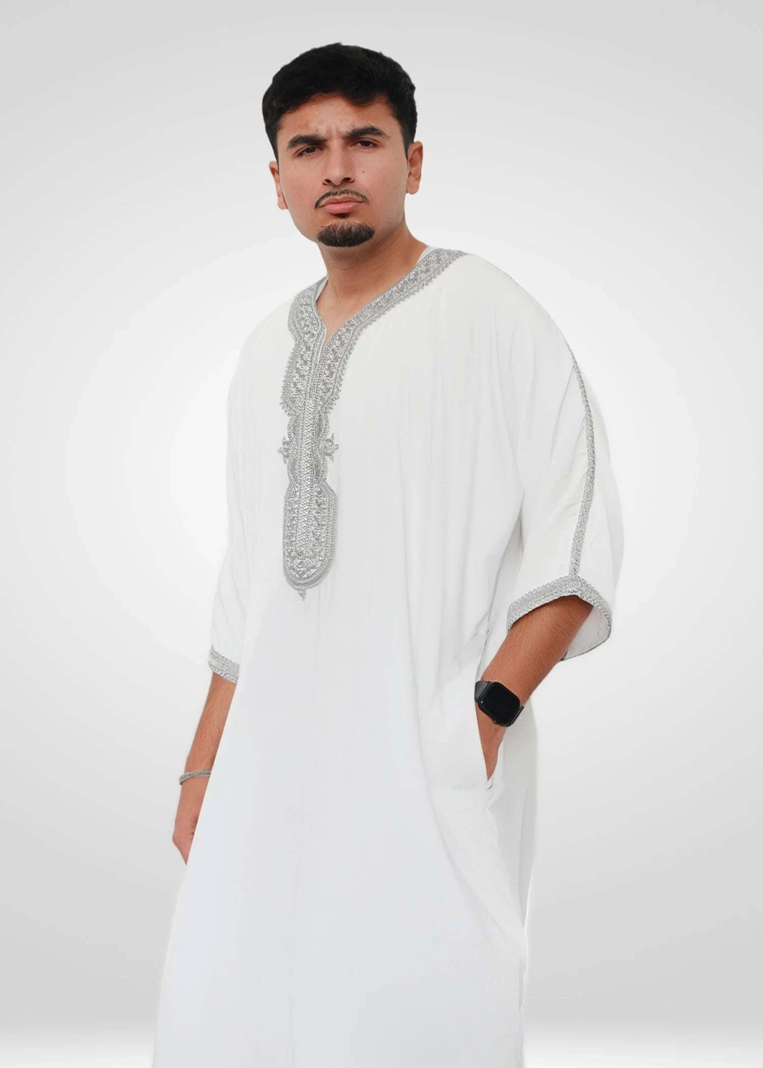 Close up of the intricate silver embroidery on the chest and neckline of the white men's thobe