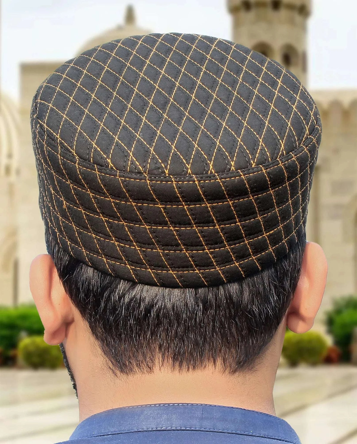 Black quilted kufi prayer cap with gold stitching for men, shown from the front