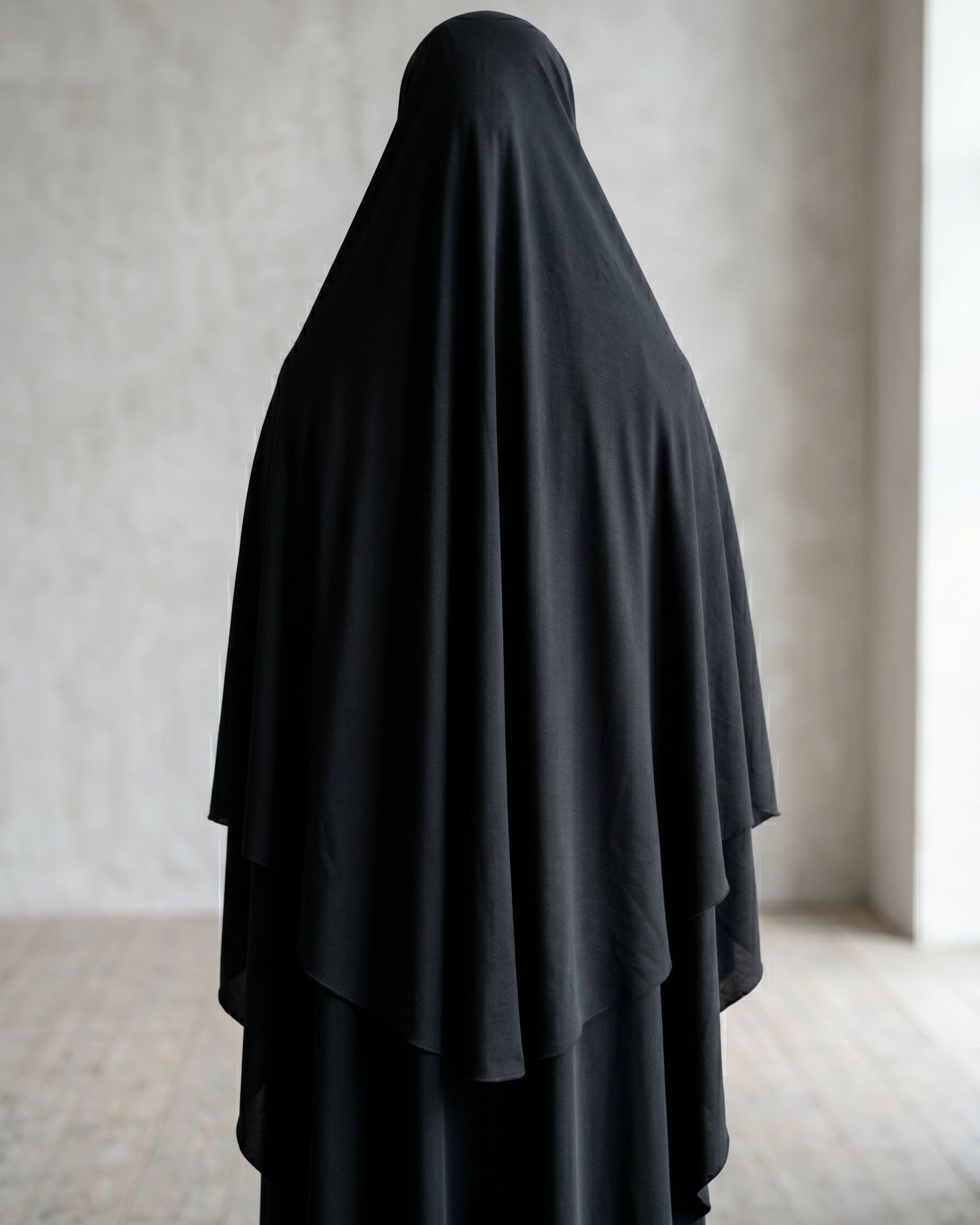 Back view of premium black slip-on khimar showing the beautiful layered fabric design and extensive back coverage, an essential piece of modest Islamic clothing for women and girls.