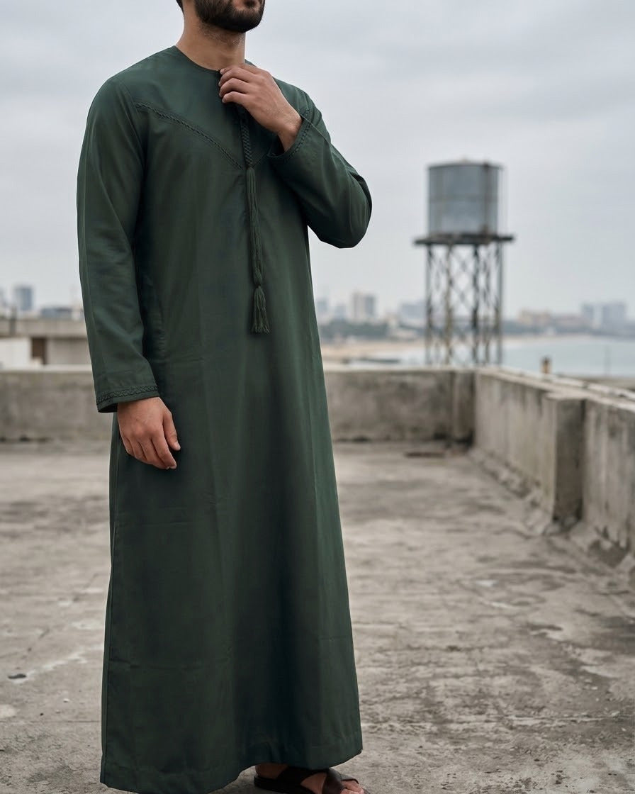 Men's Dark Green Emirati Thobe – Tailored Jubba, walking toward camera, city edge · city rooftop, overcast – The Topi Wala