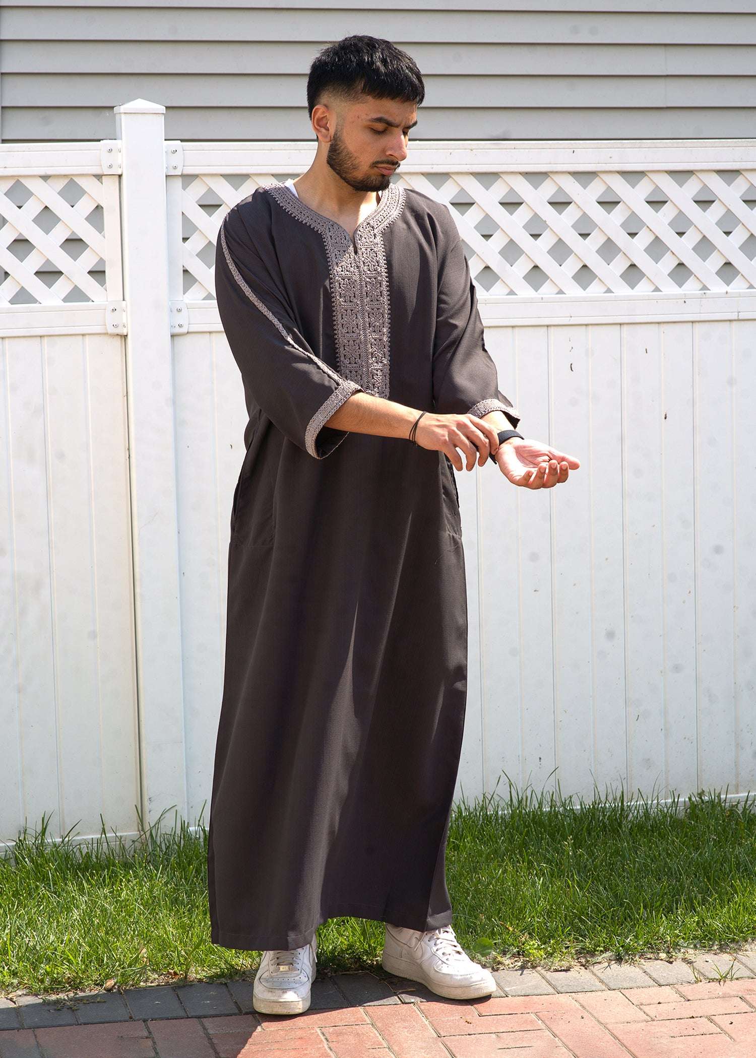 Close up of the intricate silver embroidery on the chest and neckline of the taupe men's thobe