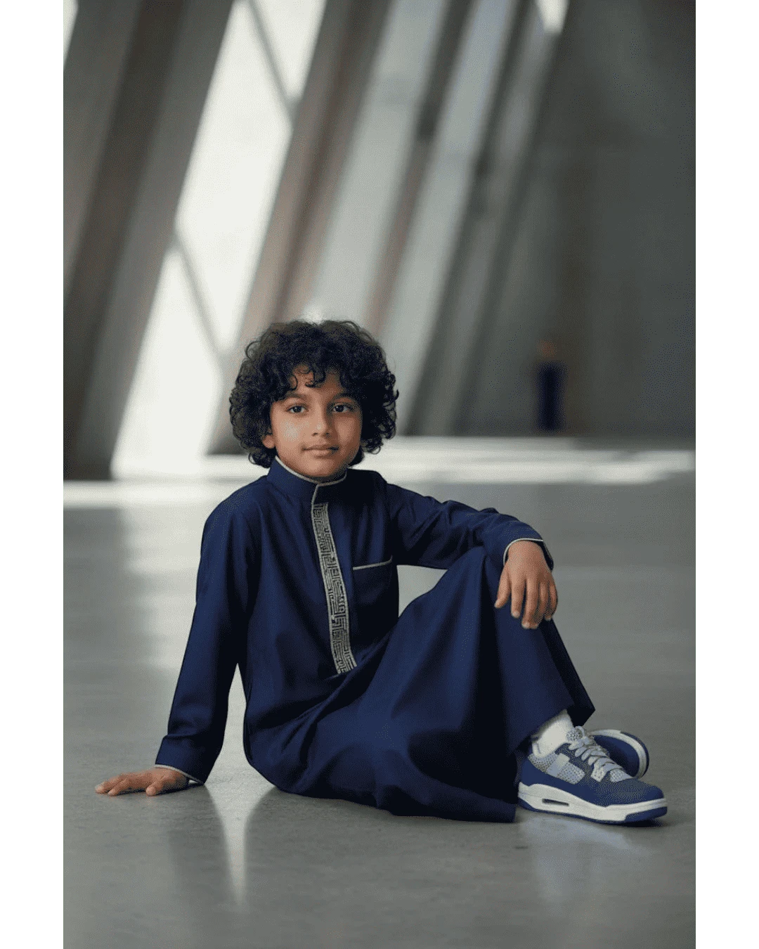 The Topi Wala navy blue boys thobe with beige and gold embroidery on the collar and cuffs. Long sleeves, mandarin collar.