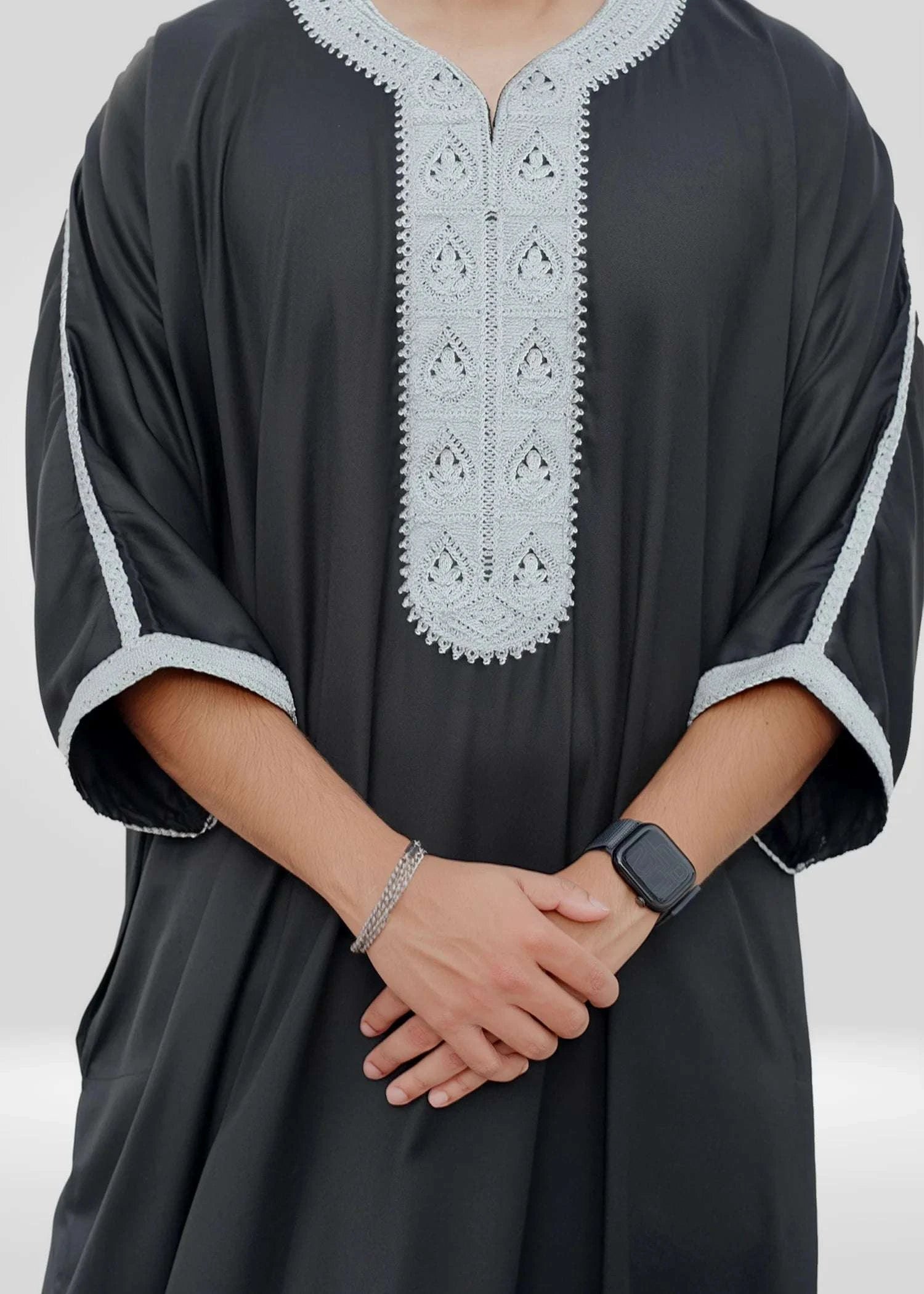 Close up of the intricate silver embroidery on the chest and neckline of the black men's thobe