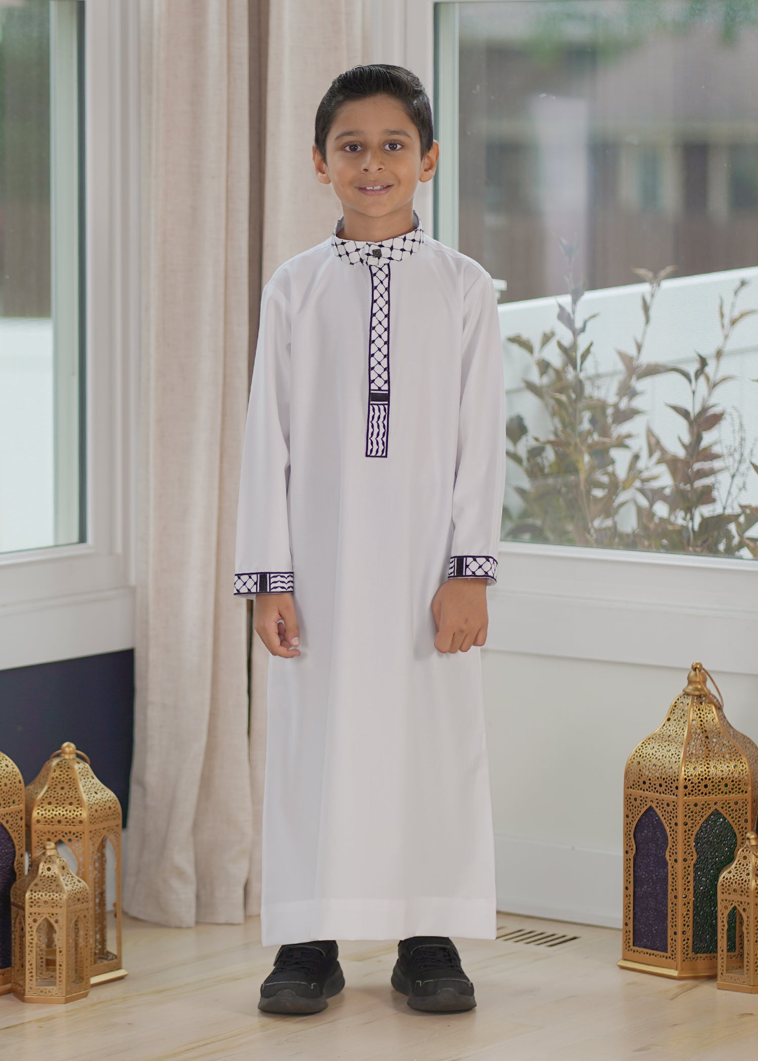 Front view of the White Palestine Kids Thobe showing the striking black kufiya embroidery on white fabric