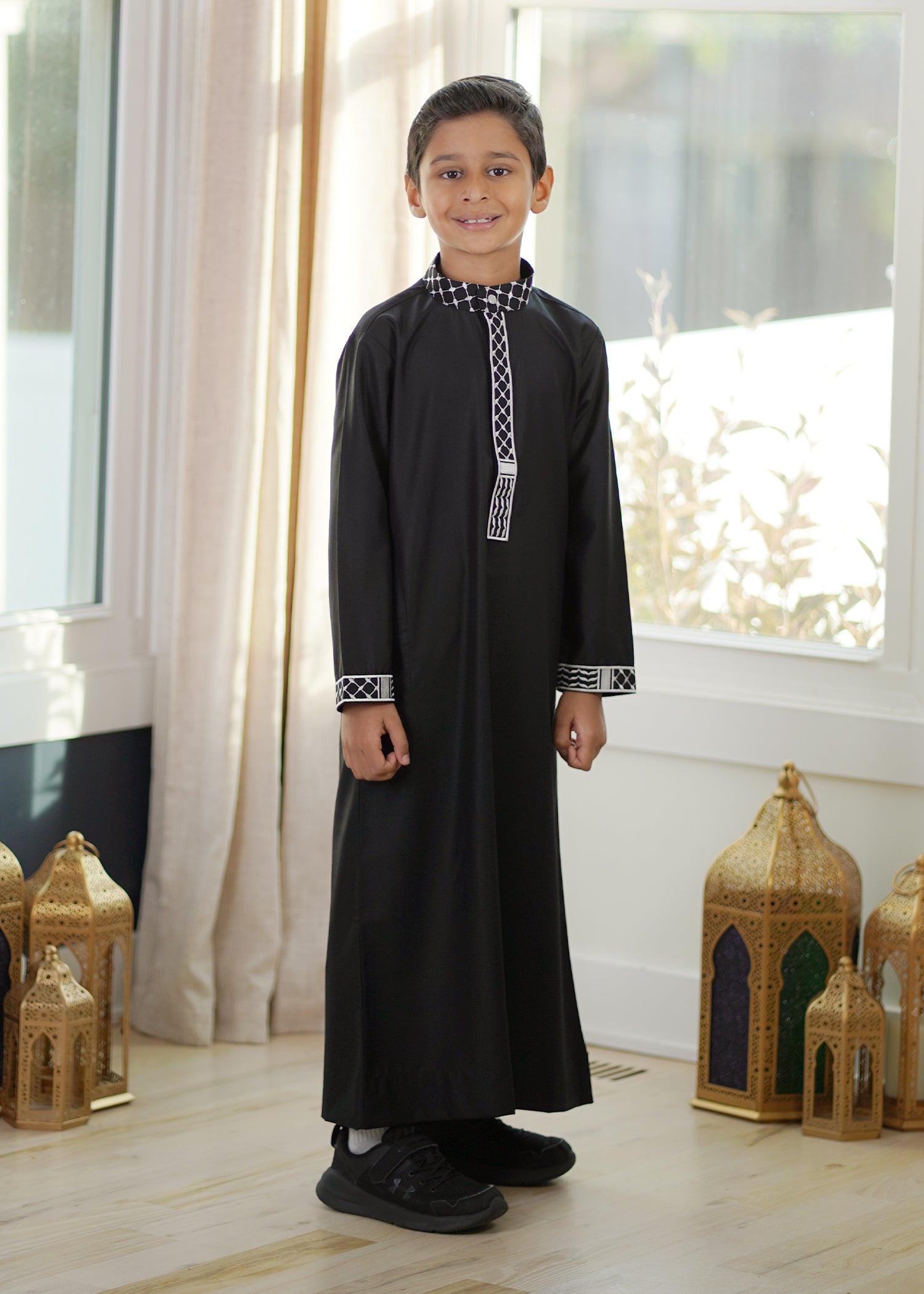 Front view of the Black Pal Kids Thobe showing striking white kufiya embroidery on black fabric