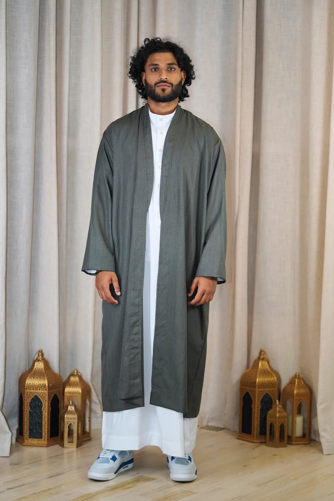 Full-length photo of a man wearing a Dark Slate Turkish Coat layered open over a white Thobe. This piece of premium modest outerwear provides a sophisticated, traditional silhouette for Islamic fashion and formal occasions.