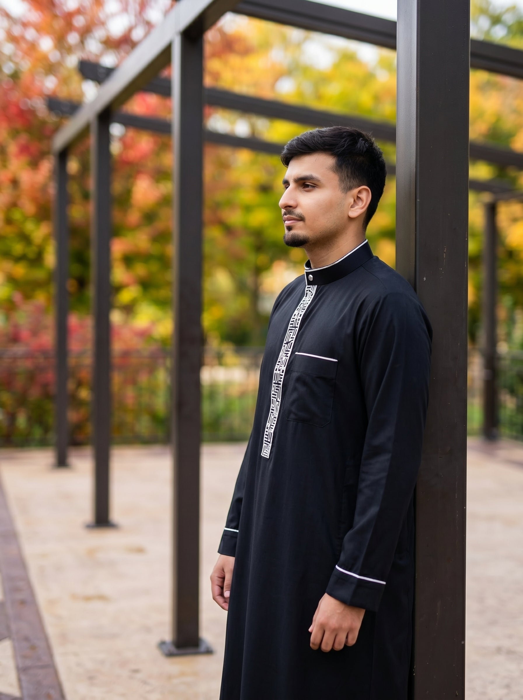 Modern black thobe with white piping sitting on a bench, high-end Islamic apparel mens collection by The Topiwala, Shopify SEO optimized for Chicago and USA modest wear searches.