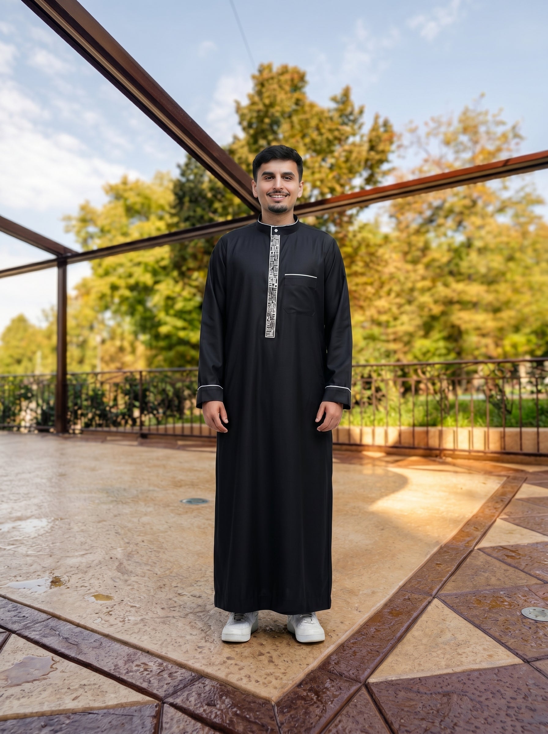Wide-angle shot of black jubba with white trim in a modern patio setting, symmetrical pose for high-end modest fashion lookbook, The Topiwala Chicago USA Shopify SEO collection.