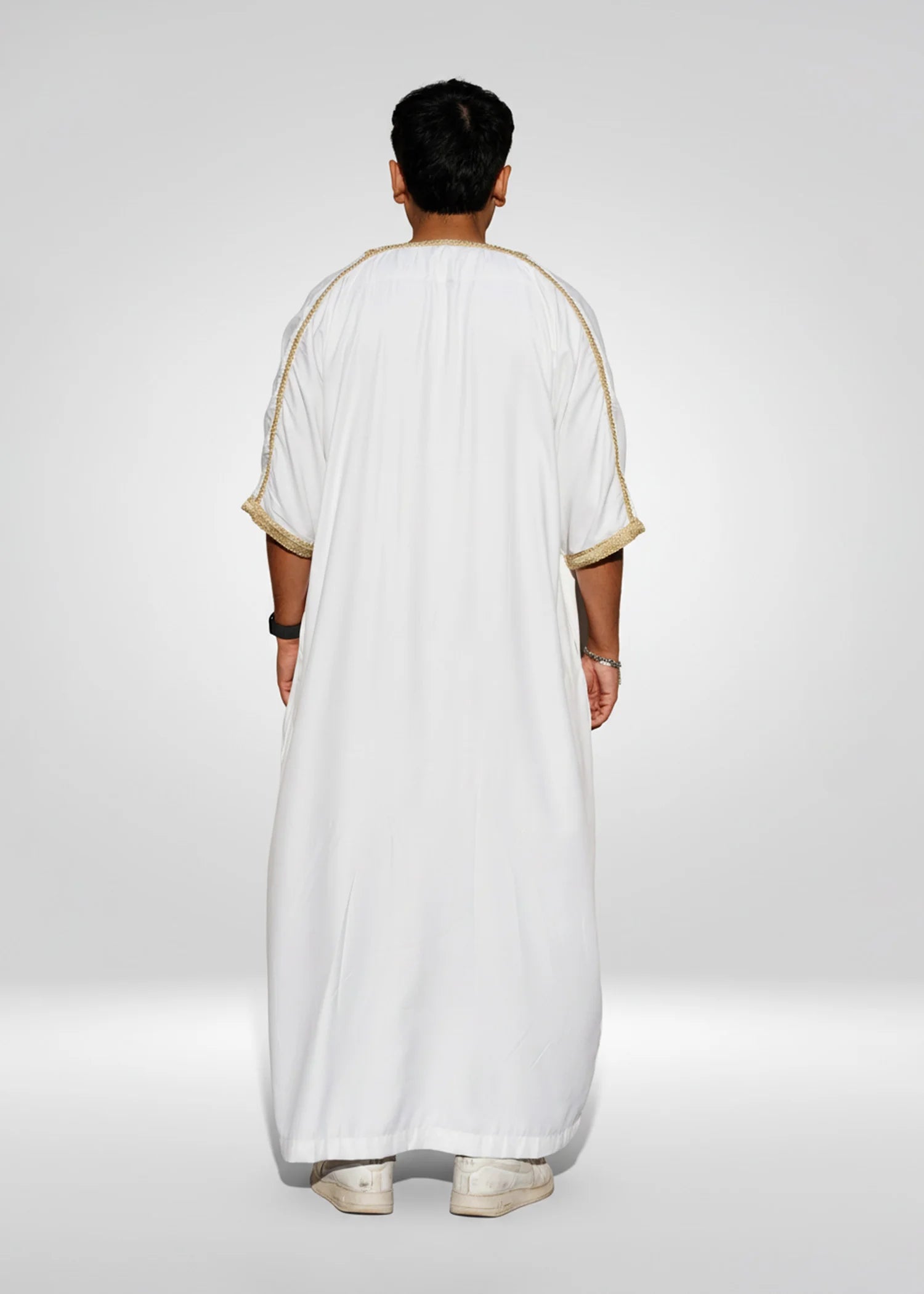 Flat lay image of the folded White & Gold Moroccan Thobe showing the premium embroidery contrast