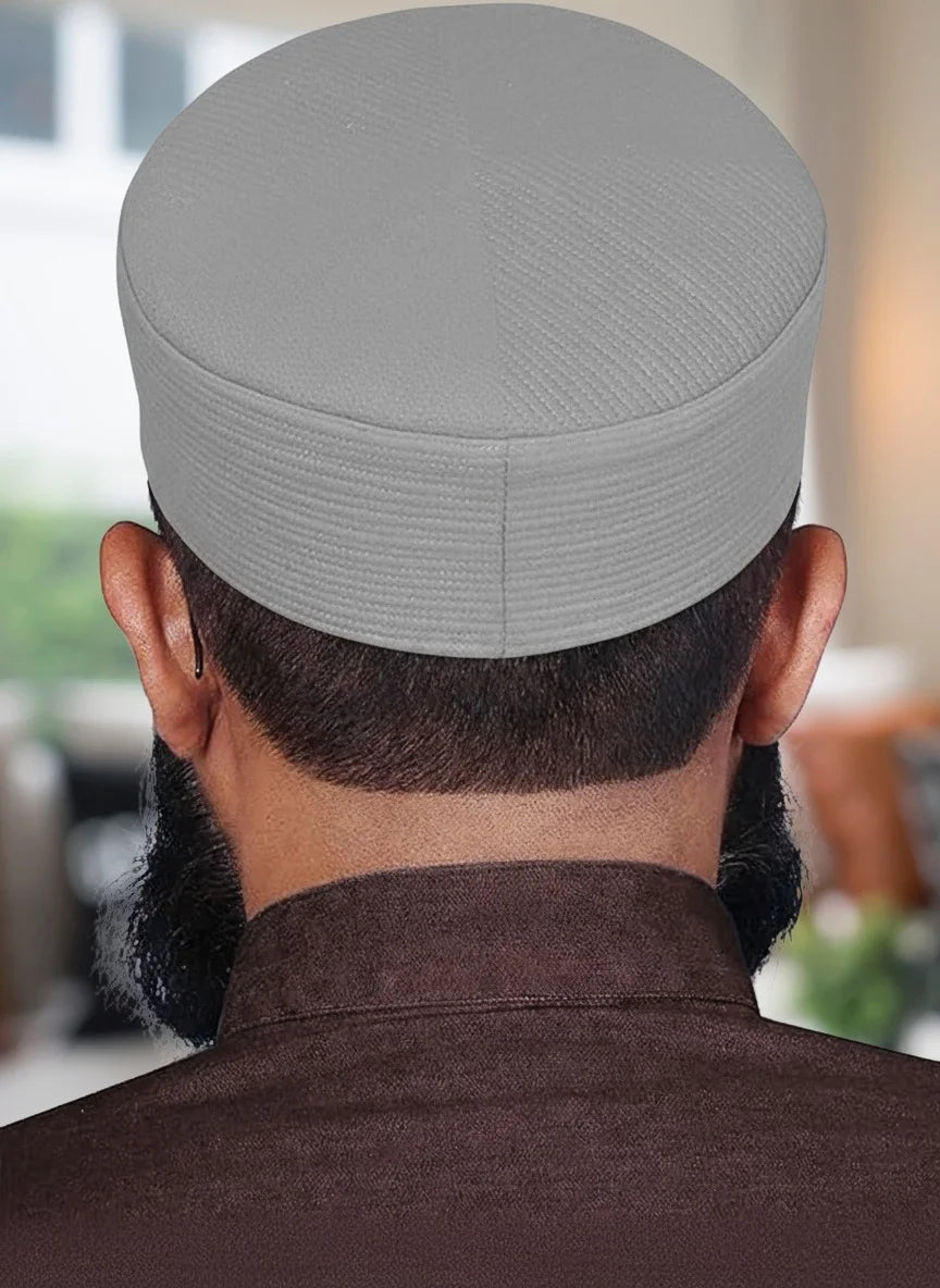Lifestyle shot of a man wearing the Barakah Kufi while raising hands for dua