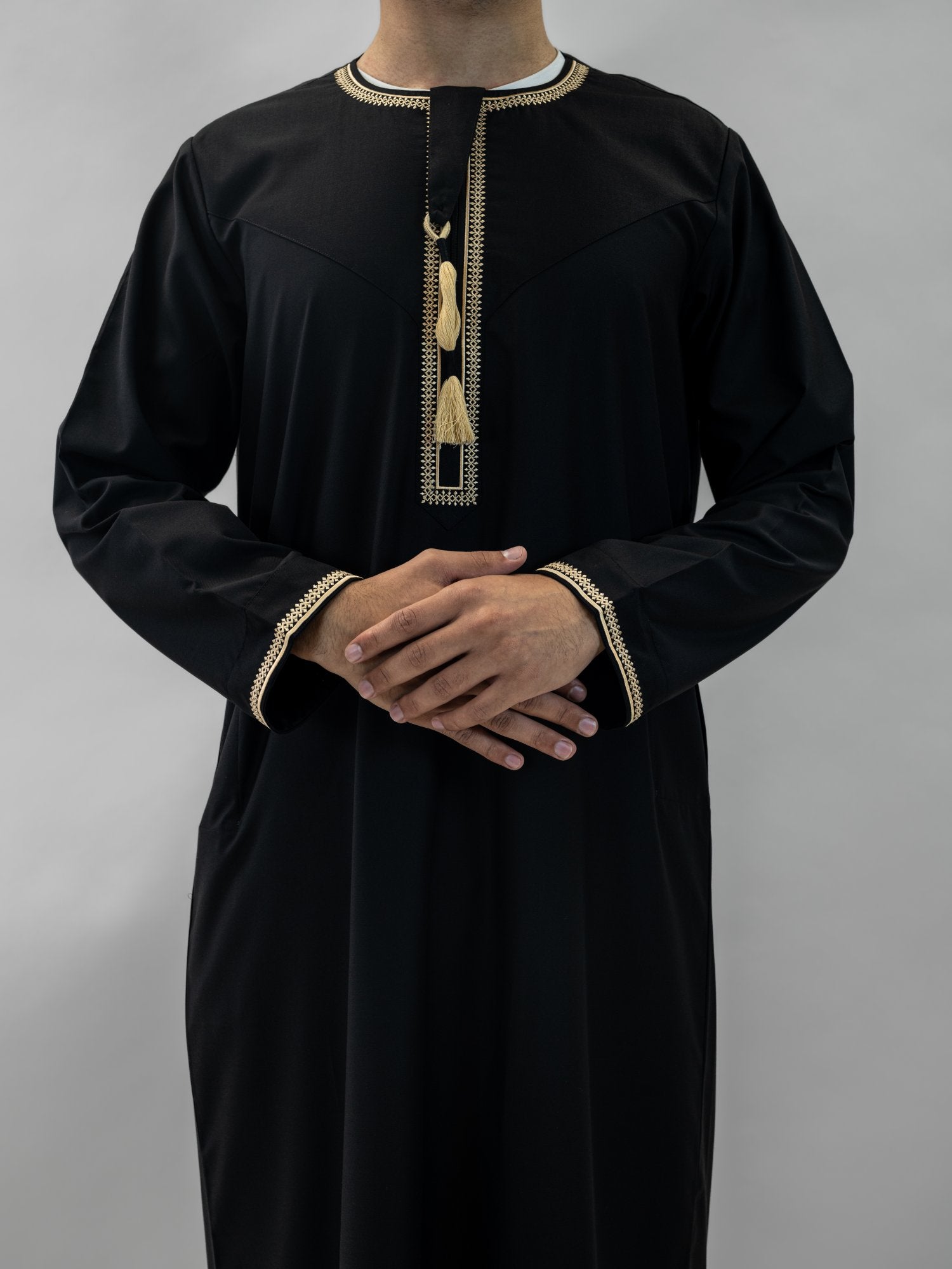 Black emirati gold trim tarboush thobe for men and boys, close-up of the collar and buttons