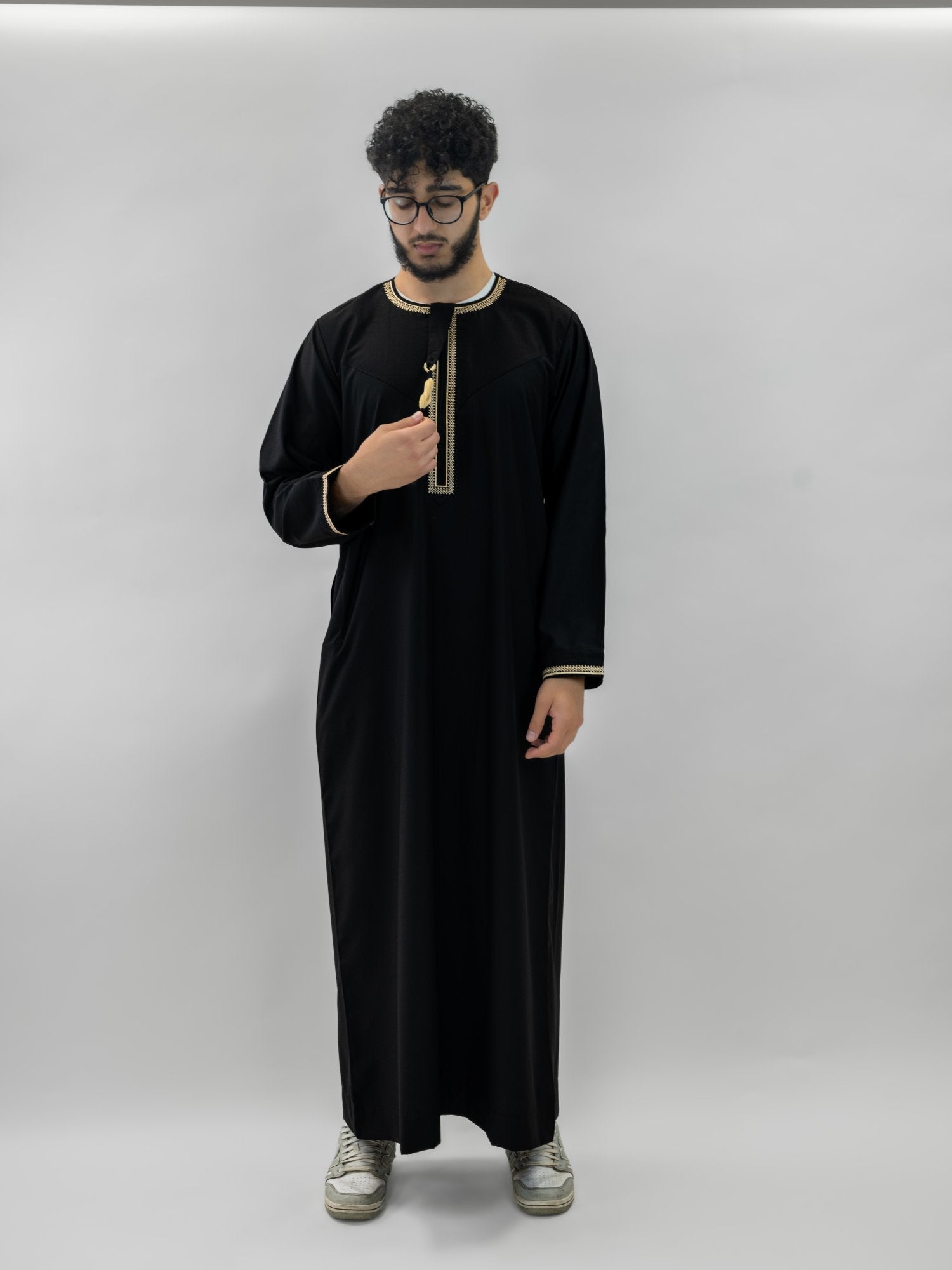 Black emirati gold trim tarboush thobe for men and boys, close-up of the fabric