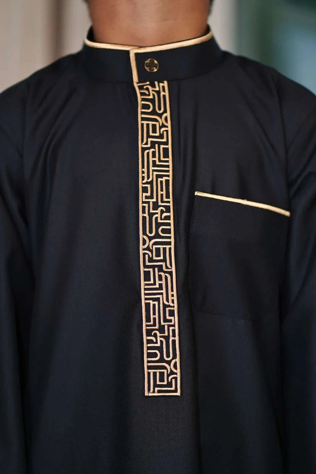 Black and gold embroidered thobe for boys, stitched pattern in close detail