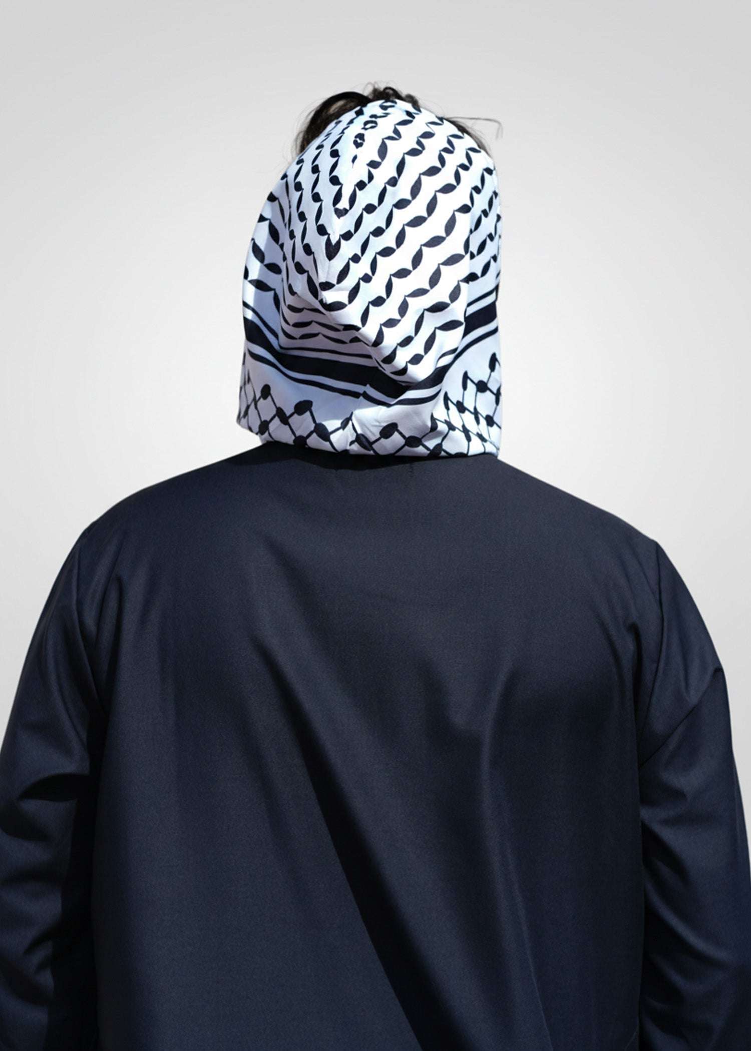 Black hooded thobe with Kufiya panel for men, close-up of the hood and zip