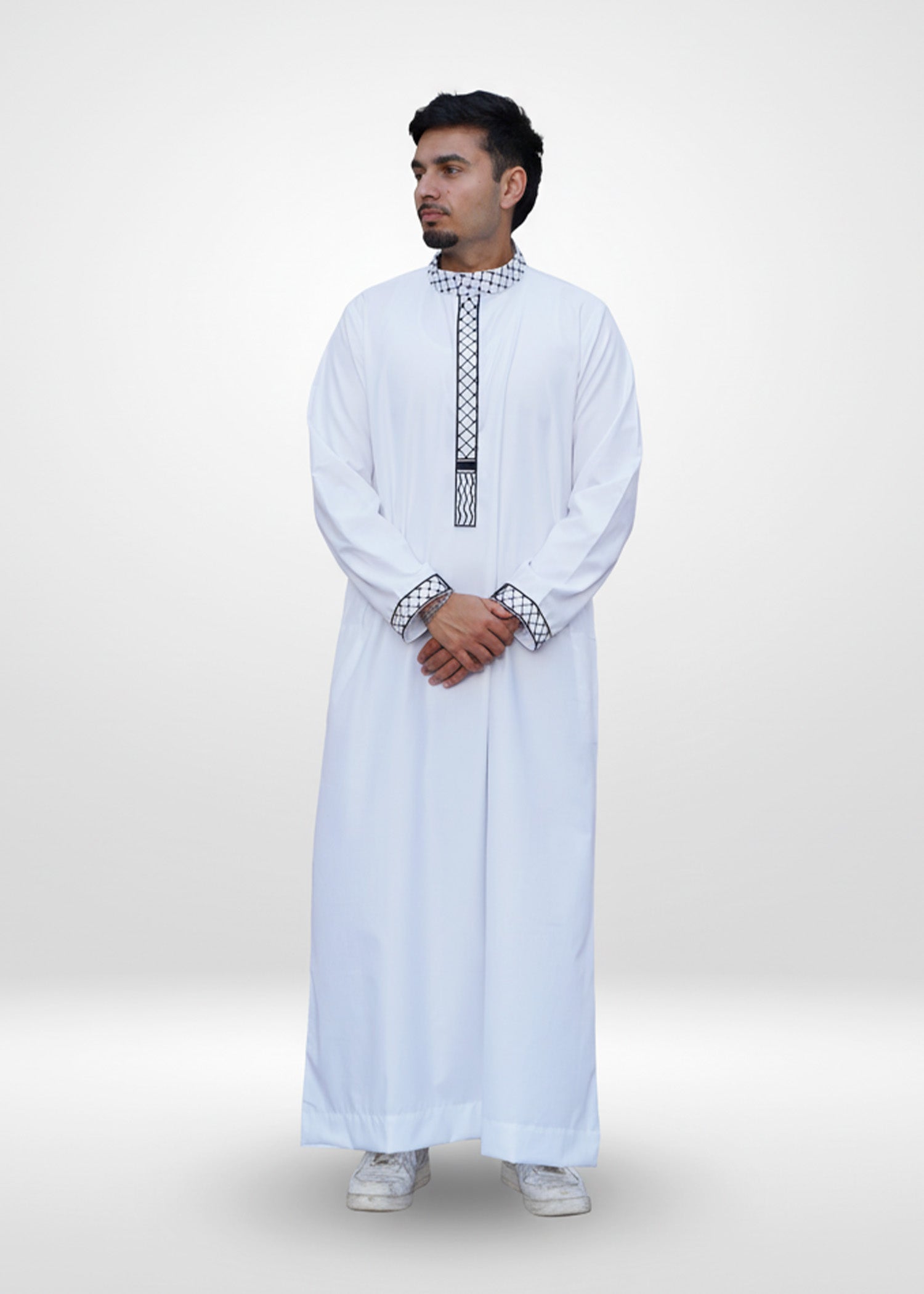 Close up of the intricate black kufiya embroidery on the mandarin collar and placket of the men's jubba