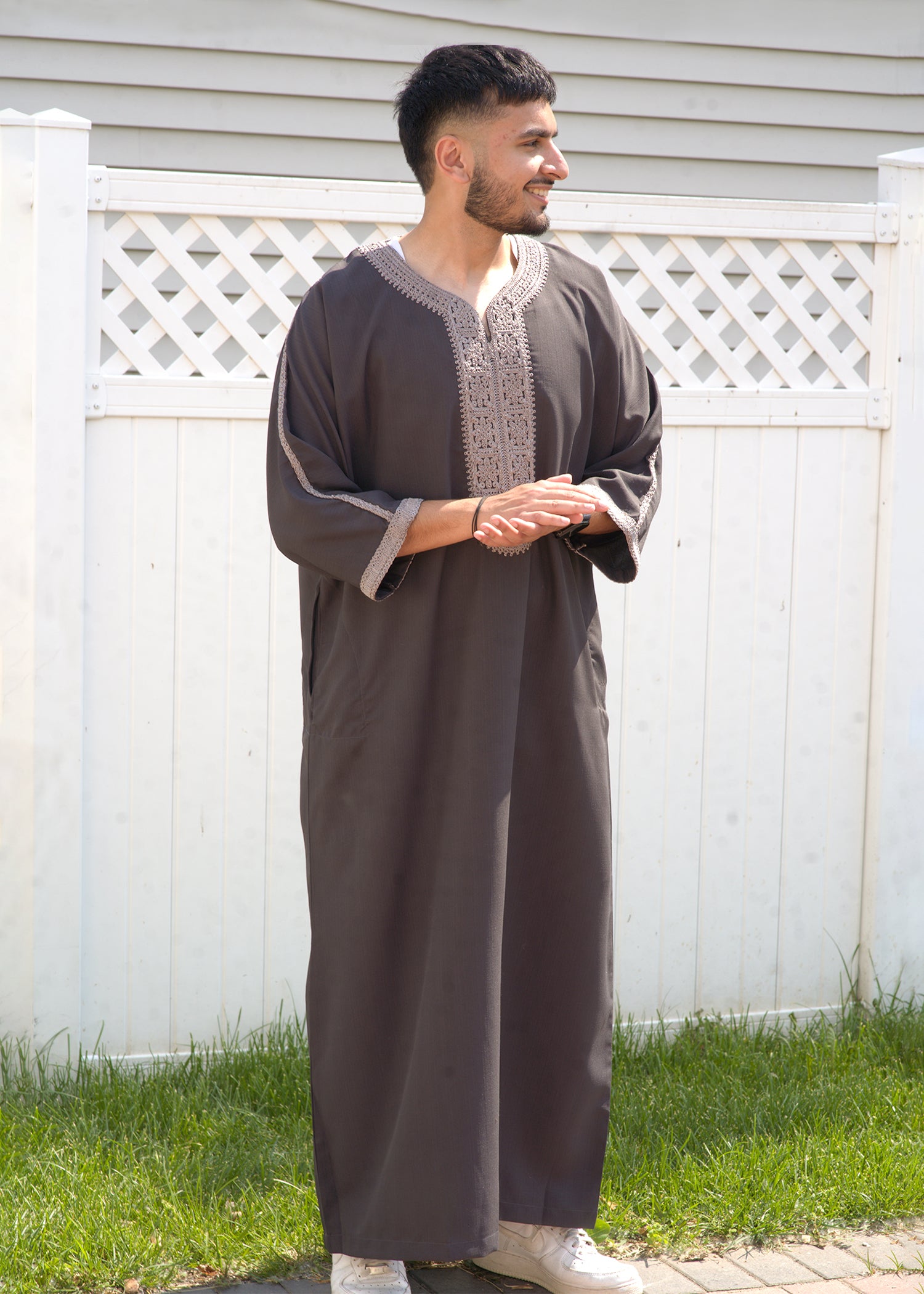 Full body front view of a man wearing the Deep Charcoal Moroccan Thobe, highlighting the dark gray fabric and light silver embroidered V-neck trim.