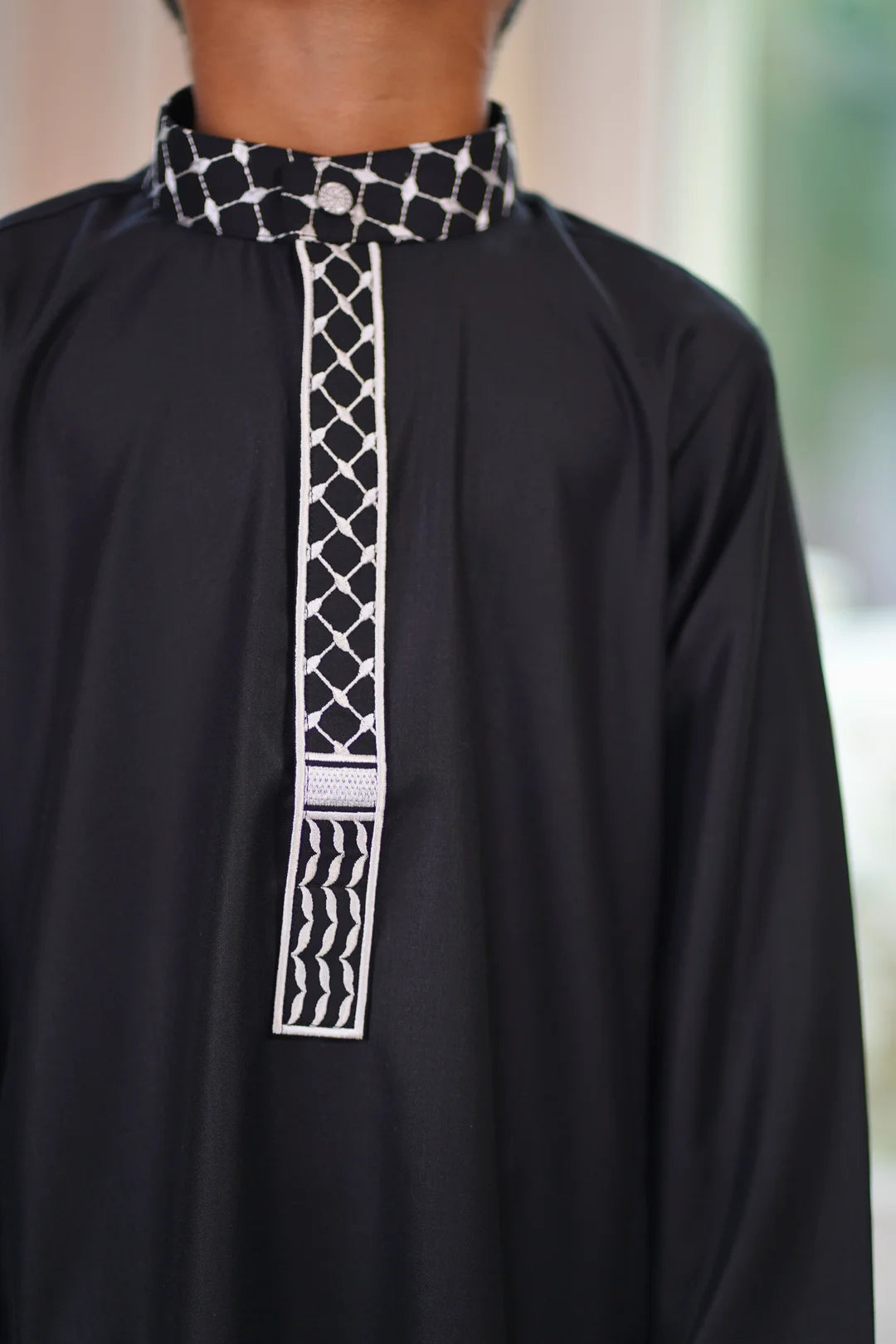 Close up of the intricate white checkered embroidery on the collar and placket
