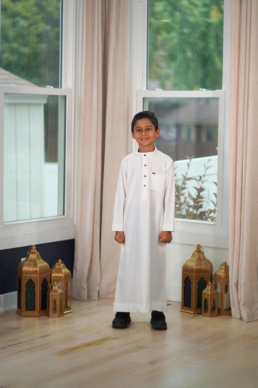 Close up of the mandarin collar and button placket on the cream boys thobe