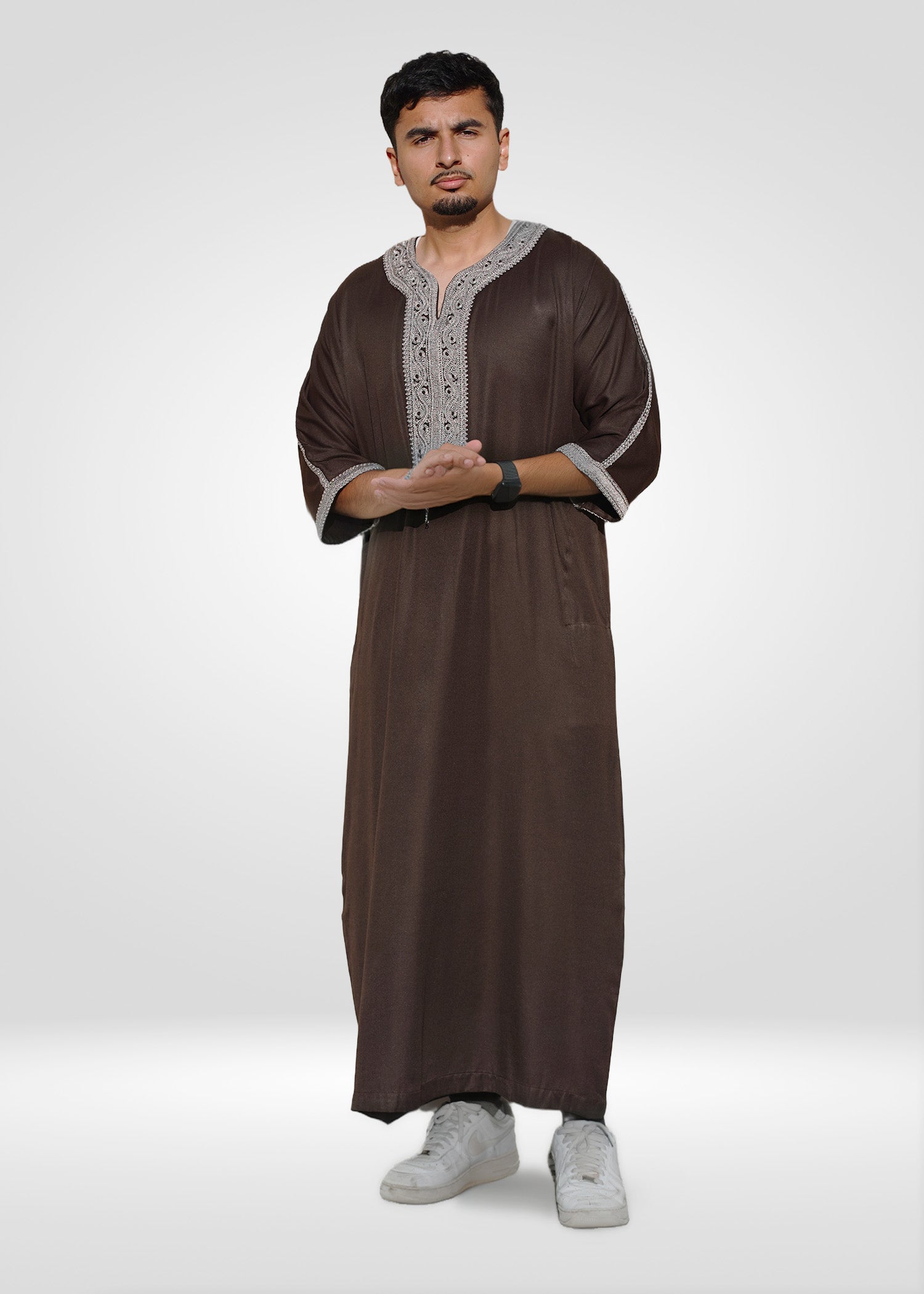 Close up of the intricate embroidery on the chest and neckline of the brown men's thobe