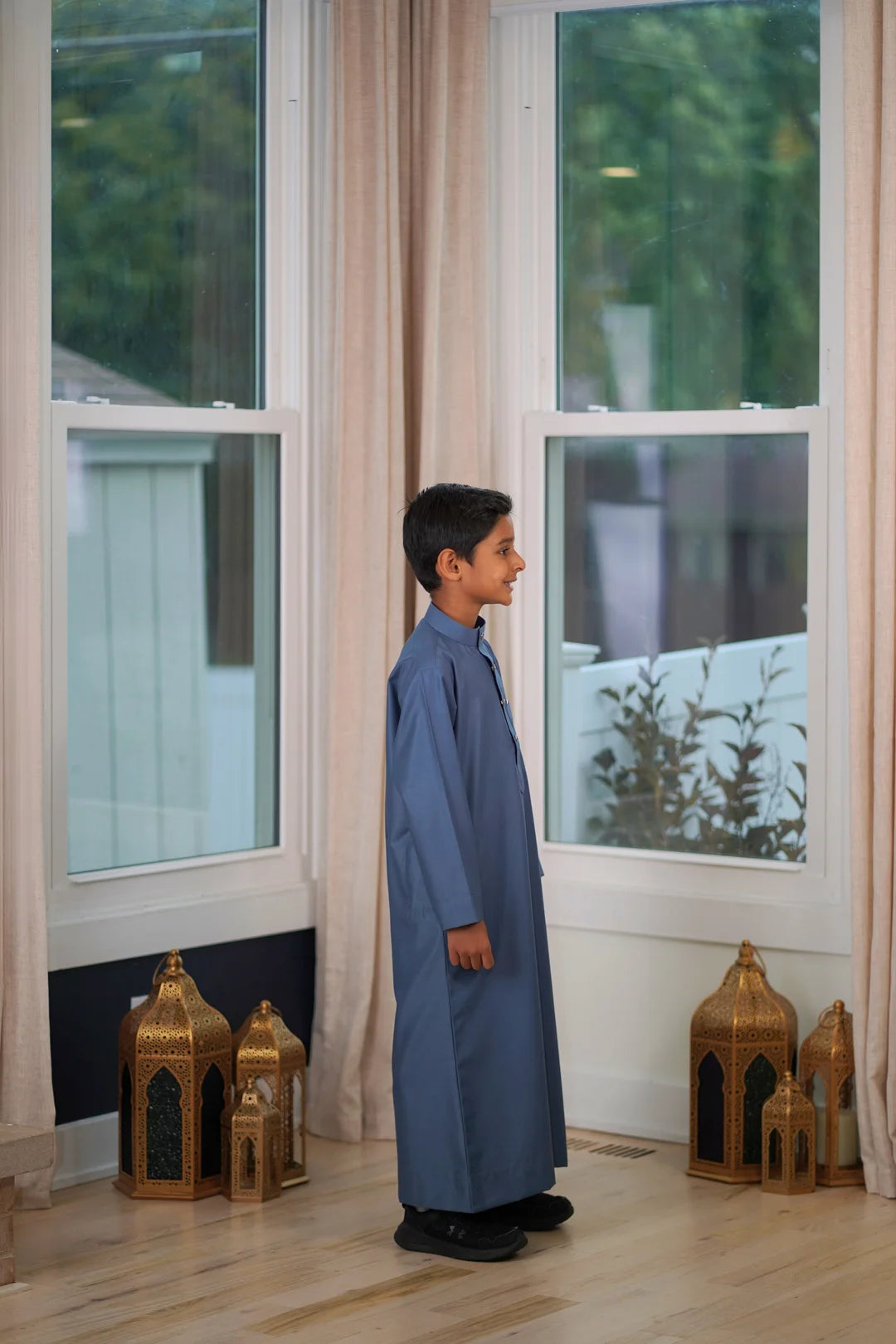 Detail view of the practical deep side pockets on the boys dusty blue jubba.