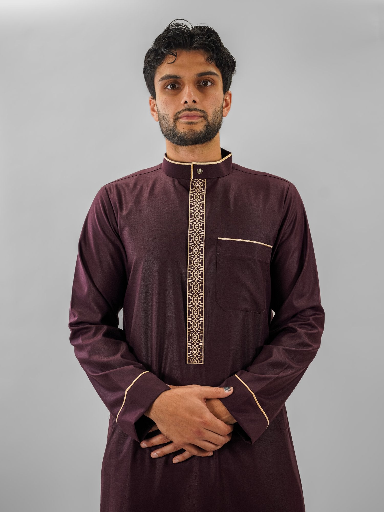 Maroon executive bronze embroidery thobe for men, worn by a model outdoors