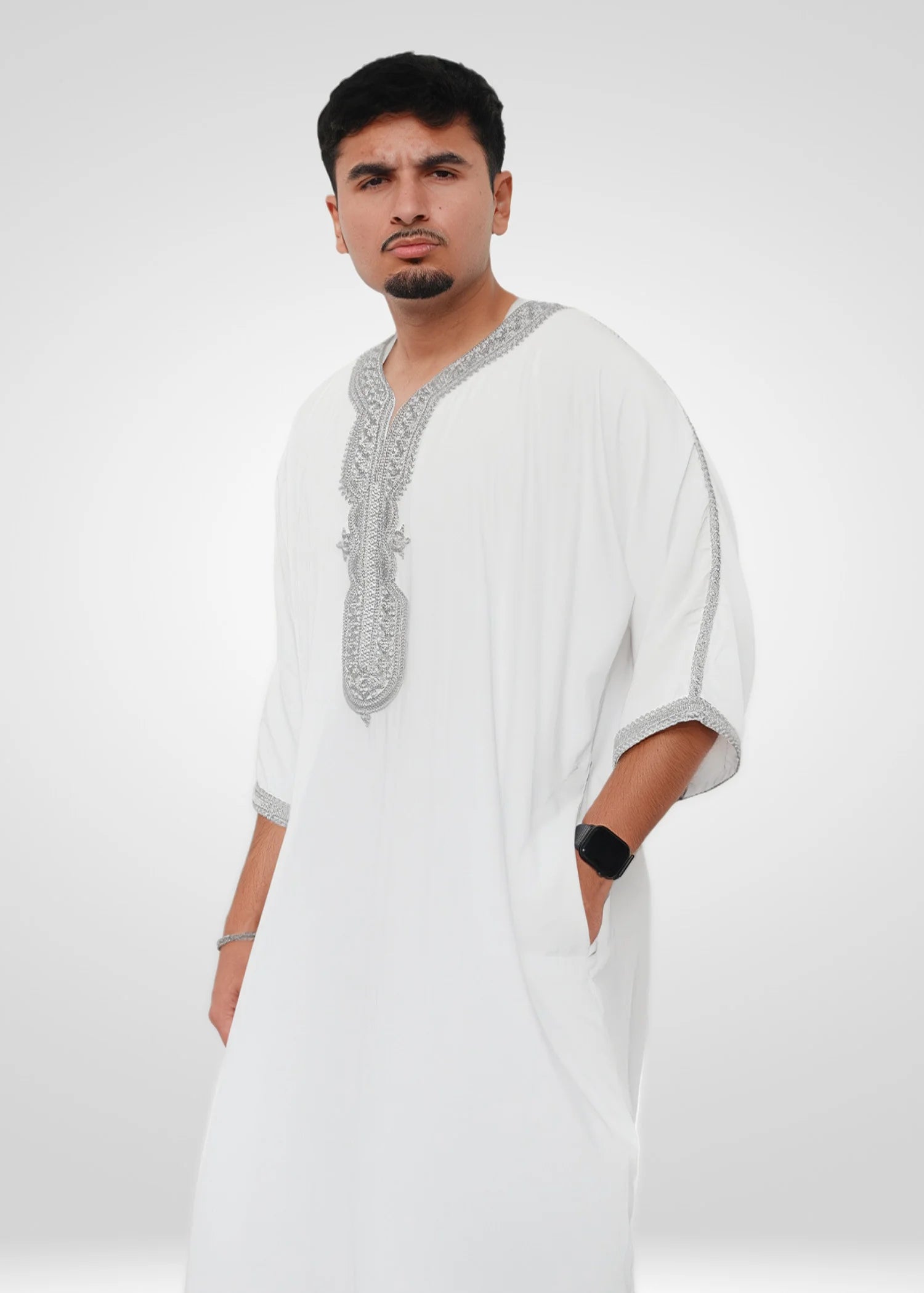 Close up of the intricate silver embroidery on the chest and neckline of the white men's thobe