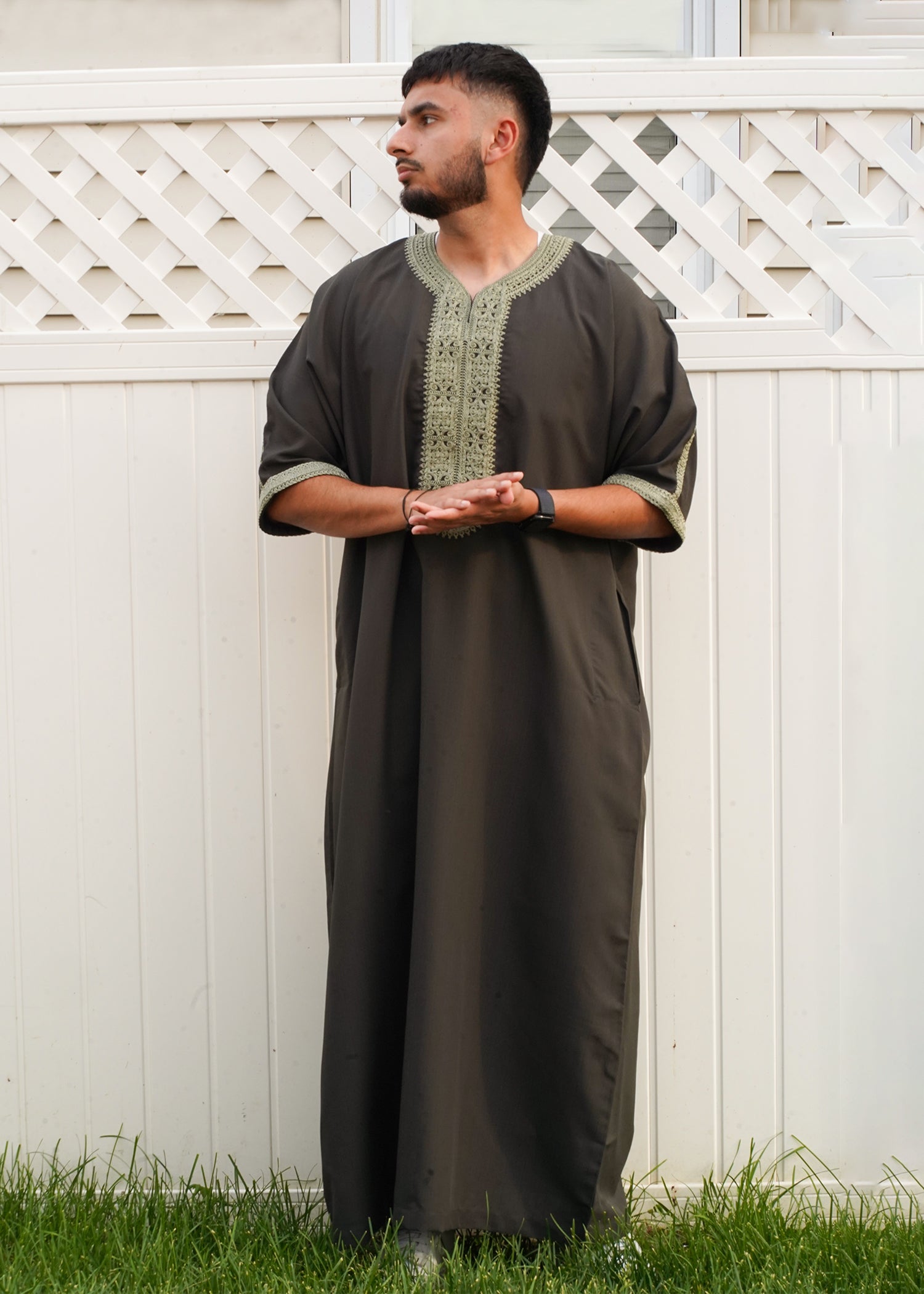 Full body front view of a man wearing the Mountain Olive Moroccan Thobe, showcasing the dark green fabric and light olive embroidered V-neck trim.