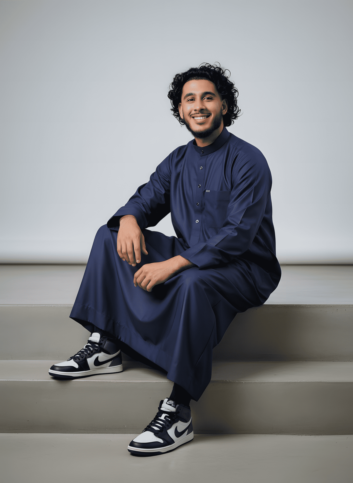 Navy blue thobe with mandarin collar for men, worn by a model outdoors