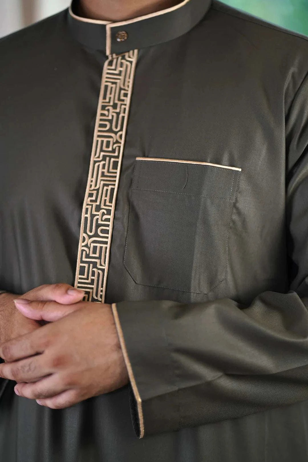 Olive green and gold embroidered thobe for men, showing the length and sleeve line