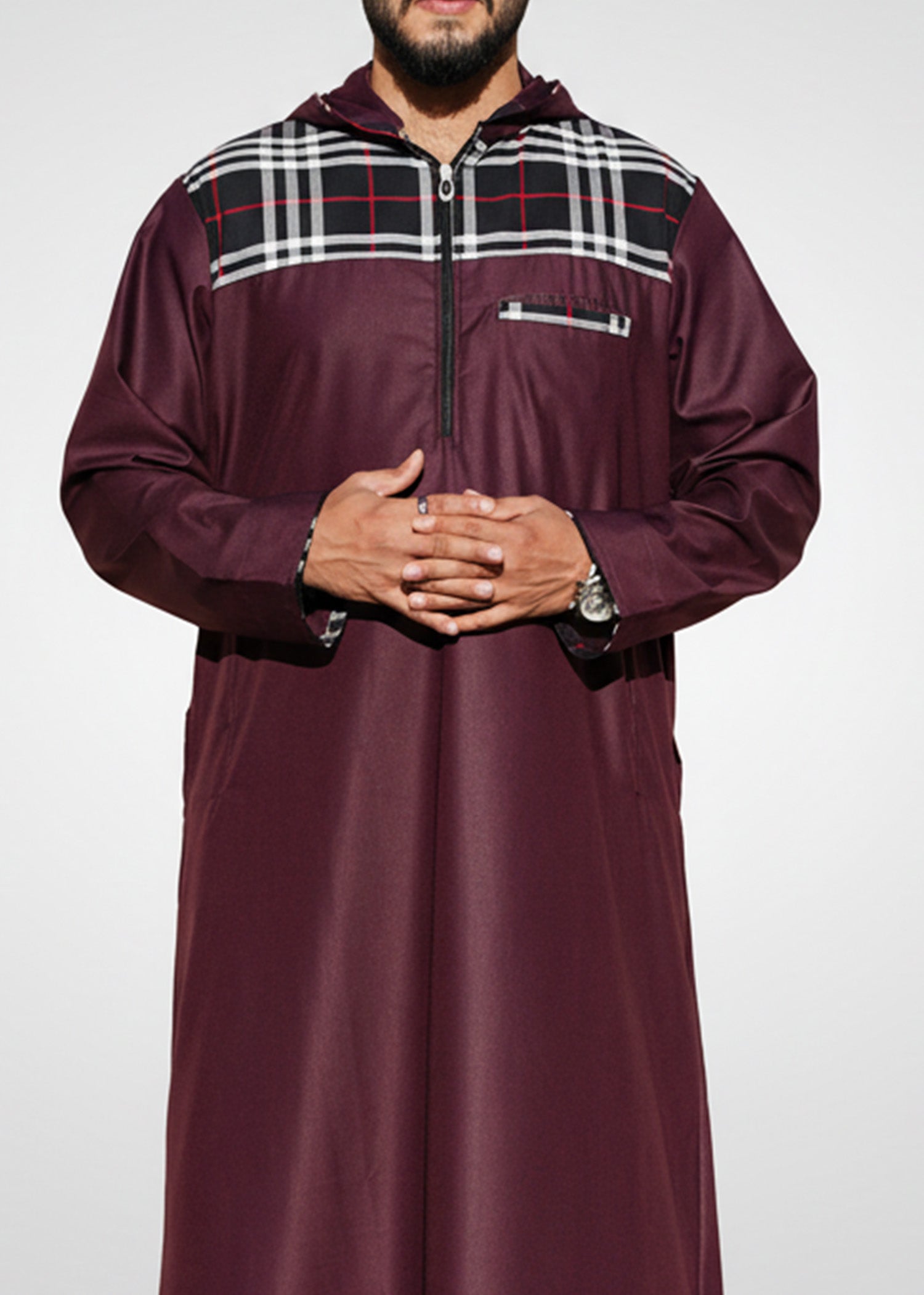 Lifestyle shot of a man wearing the maroon hoodie thobe, looking confident and stylish