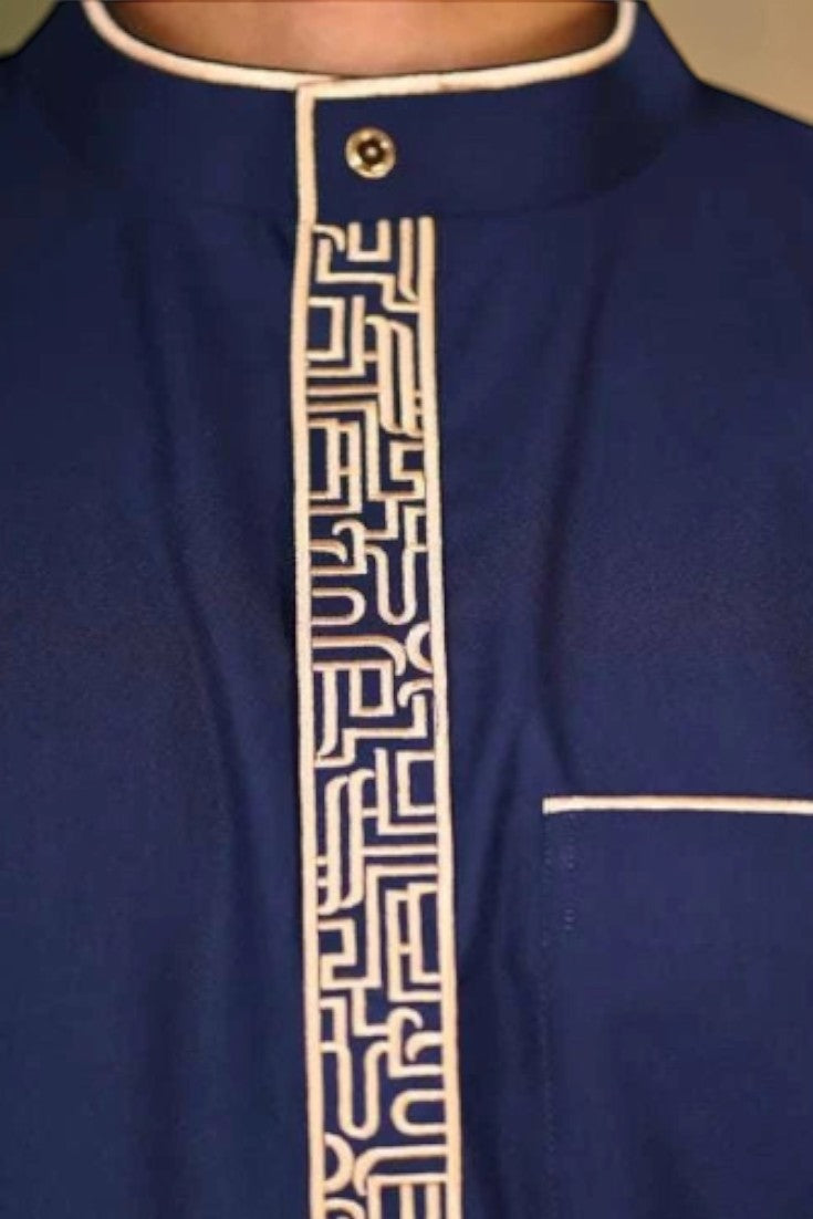 Navy blue and beige thobe for men, worn by a model outdoors