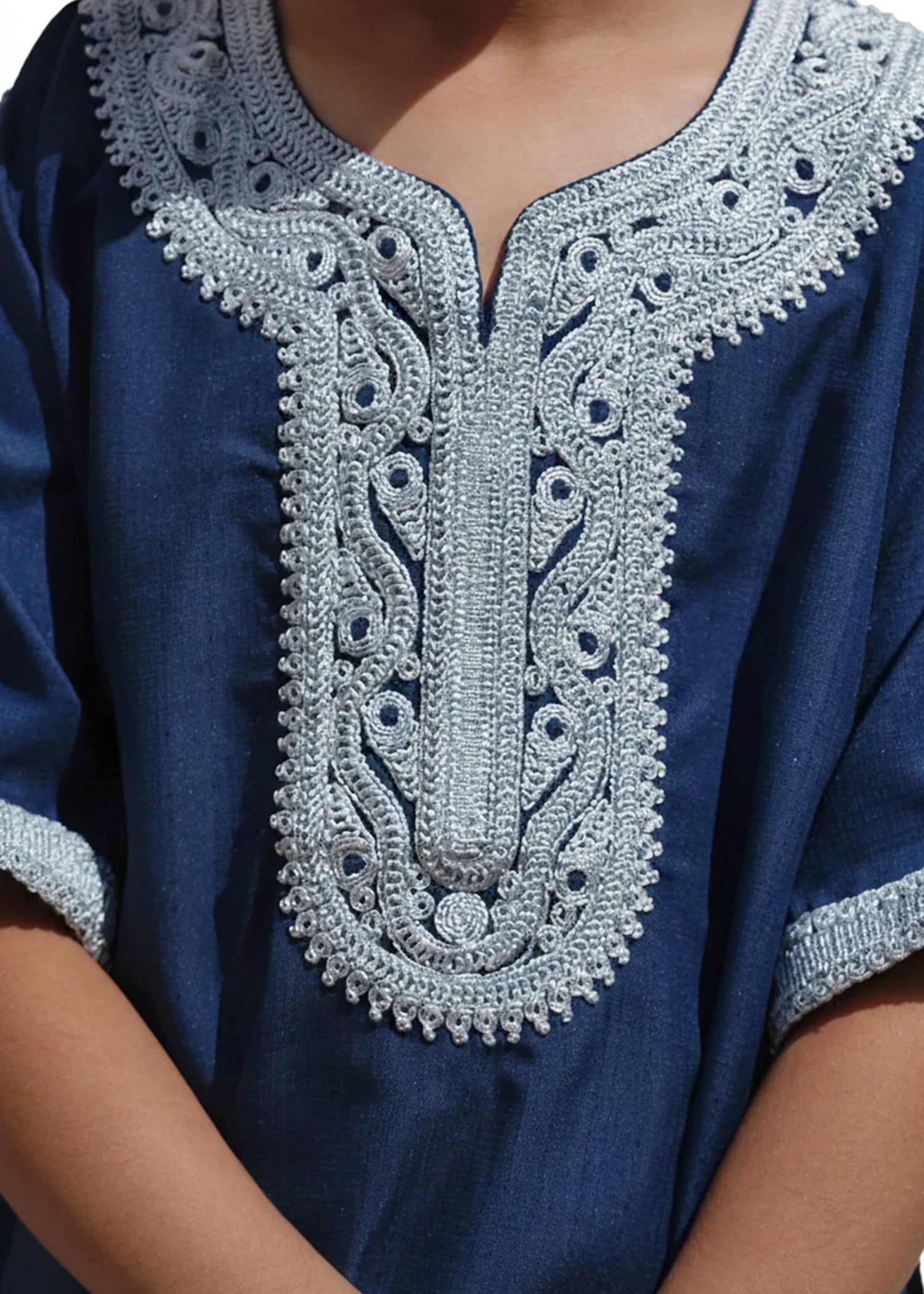 Close up of the intricate silver stitching on the chest of the royal blue boys thobe