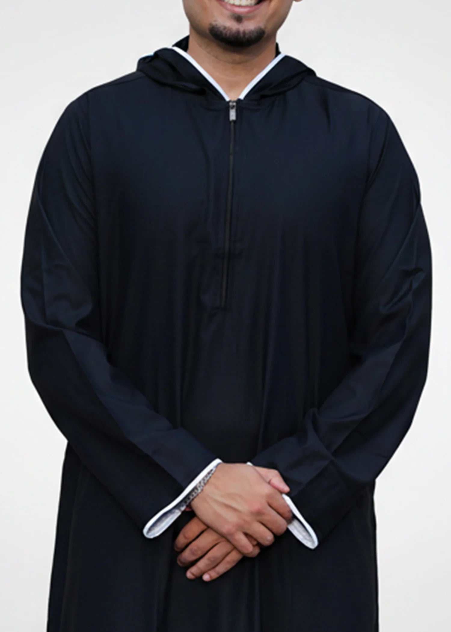 Close up of the white contrast piping running along the edge of the black hood on the men's jubba