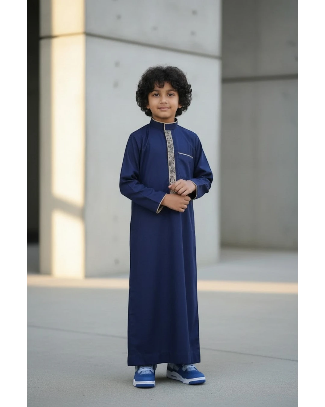 The Topi Wala navy blue boys thobe with beige and gold embroidery on the collar and cuffs.