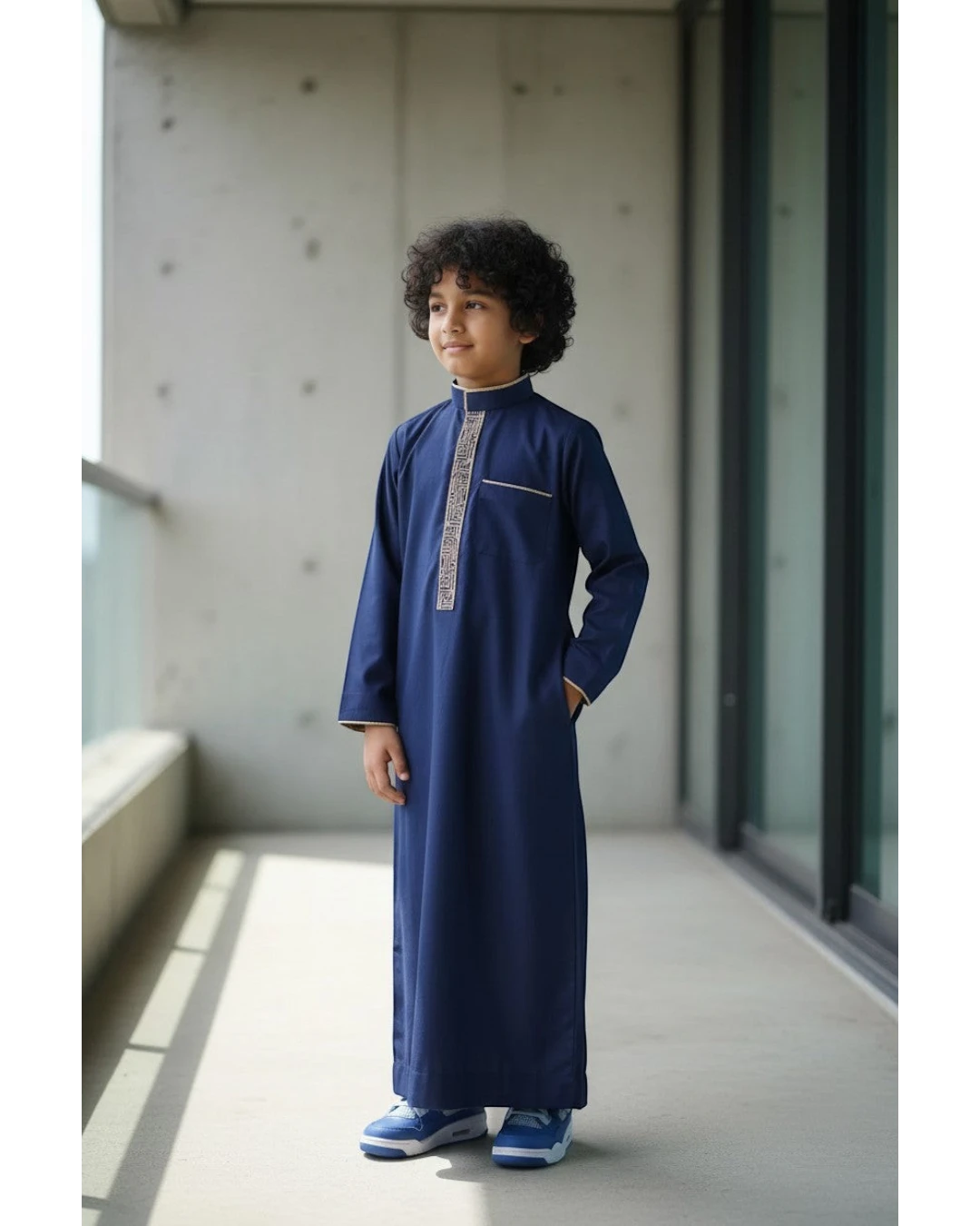 The Topi Wala navy blue boys thobe with beige and gold embroidery on the collar and cuffs. Long sleeves.